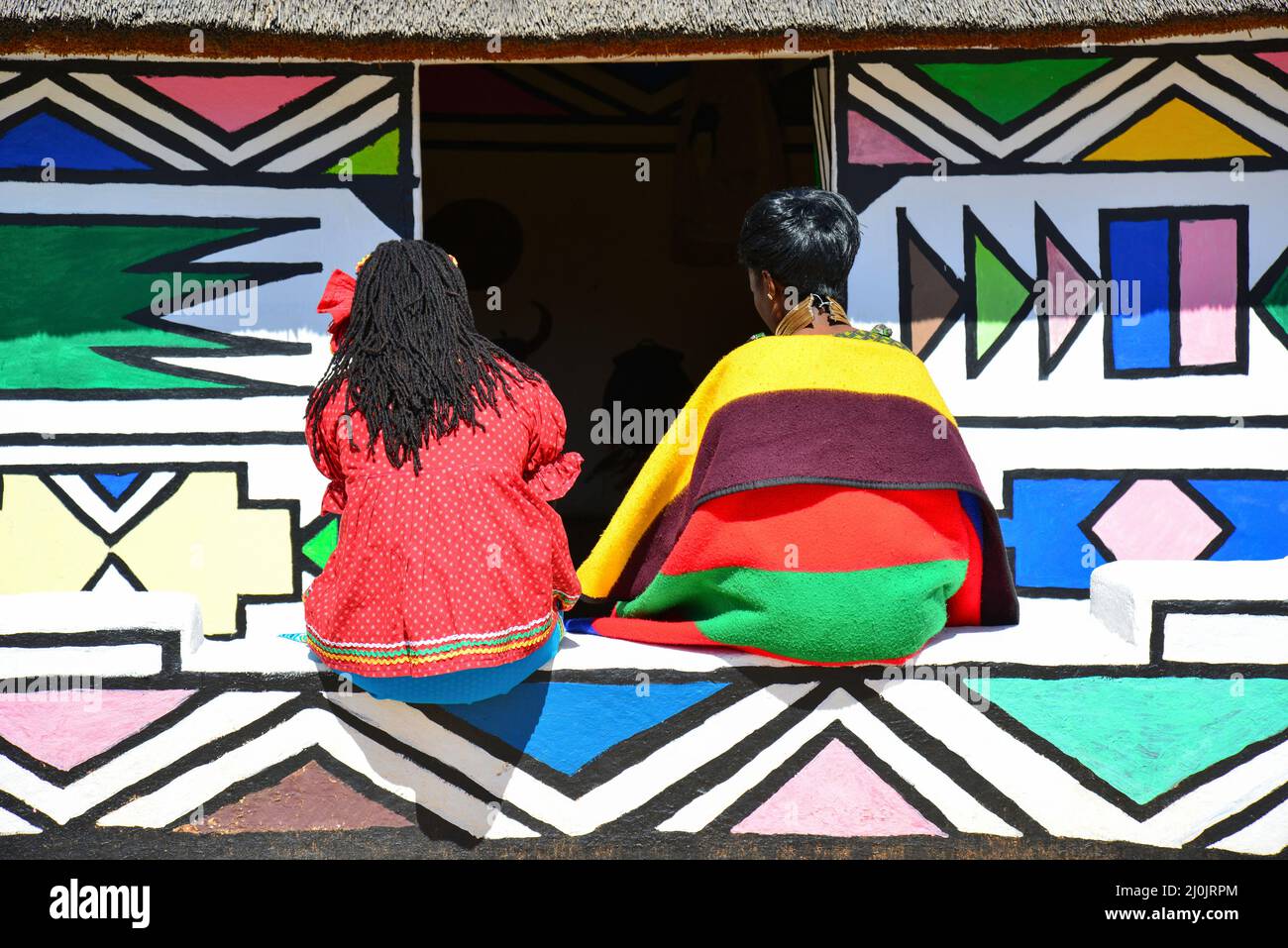 Les femmes Ndebele et hut à Motseng Village culturel, Sun City Resort, Pilanesberg, Province du Nord Ouest de la République d Afrique du Sud Banque D'Images