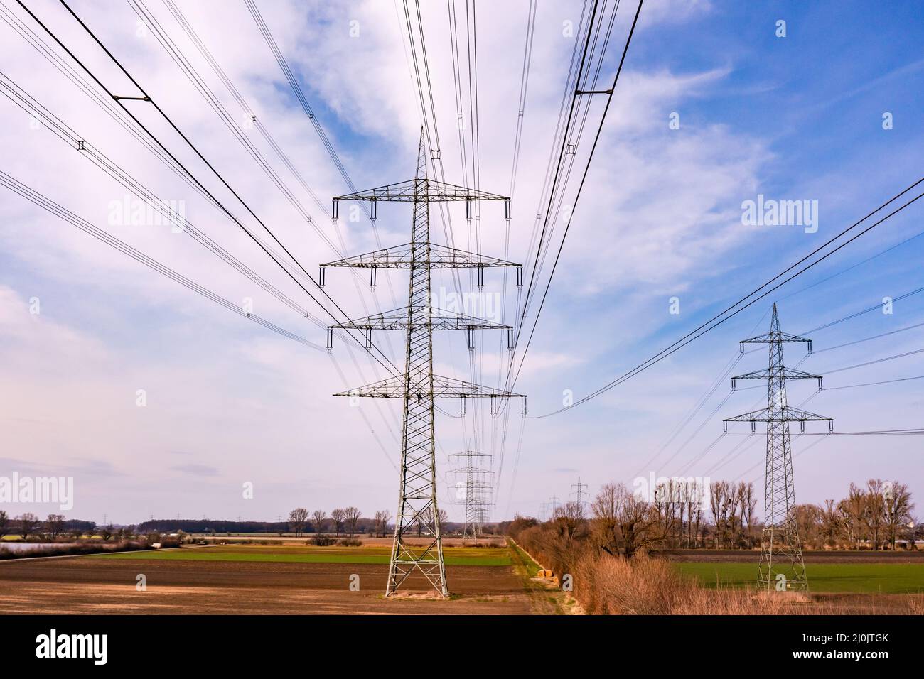 Beaucoup de pylônes à haute tension dans une rangée dans la zone rurale de l'Energiewende allemande vu du point de vue de drone, Allemagne Banque D'Images