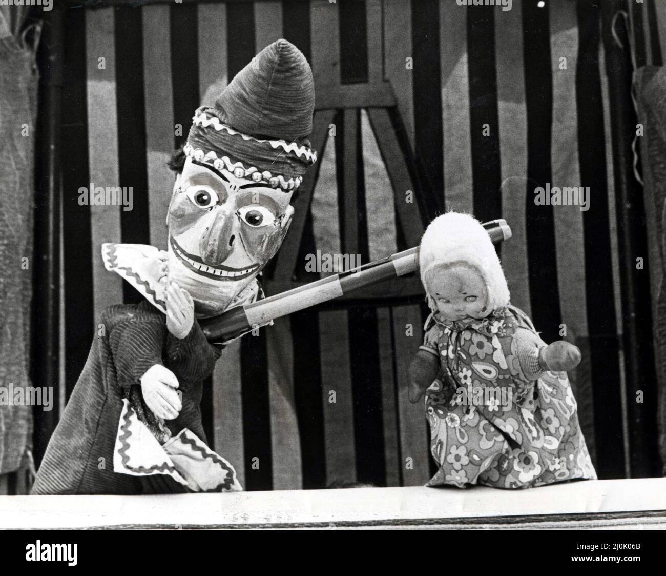 Punch and Judy - « c'est la façon du faire ! » M. Punch (à gauche) explique à Cardfif Childminders ce qu'il ne faut pas faire quand on vous laisse tenir le bébé. La Cardiff Childminders Association a organisé aujourd'hui (Wed) un pique-nique pour l'enfant à Victoria Park, Cardiff. 17th juin 1981. Banque D'Images