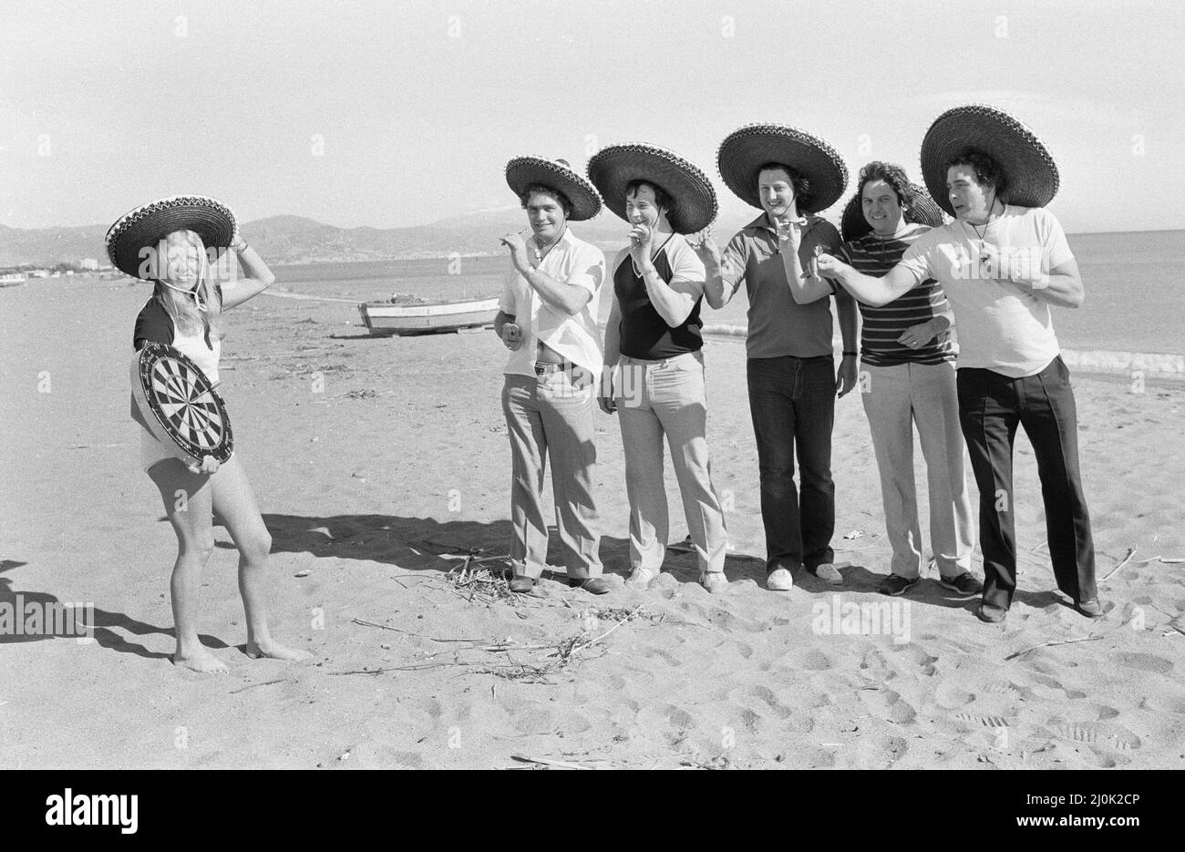 Eric Bristow, joueur de fléchettes britannique, pose sur la plage avec Maureen Flowers et d'autres joueurs de draft britanniques à Torremolinos Del Mar sur la Costa Del sol en Espagne, avant le championnat méditerranéen Open Darts. 31st janvier 1982. Banque D'Images