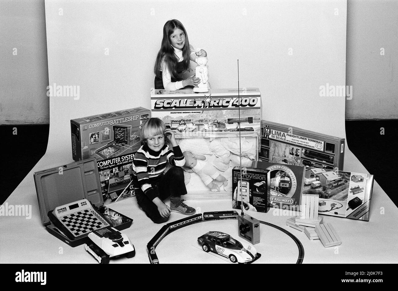 Un jeune garçon et une fille avec une sélection de jouets pour enfants pour Noël. Décembre 1980. Banque D'Images