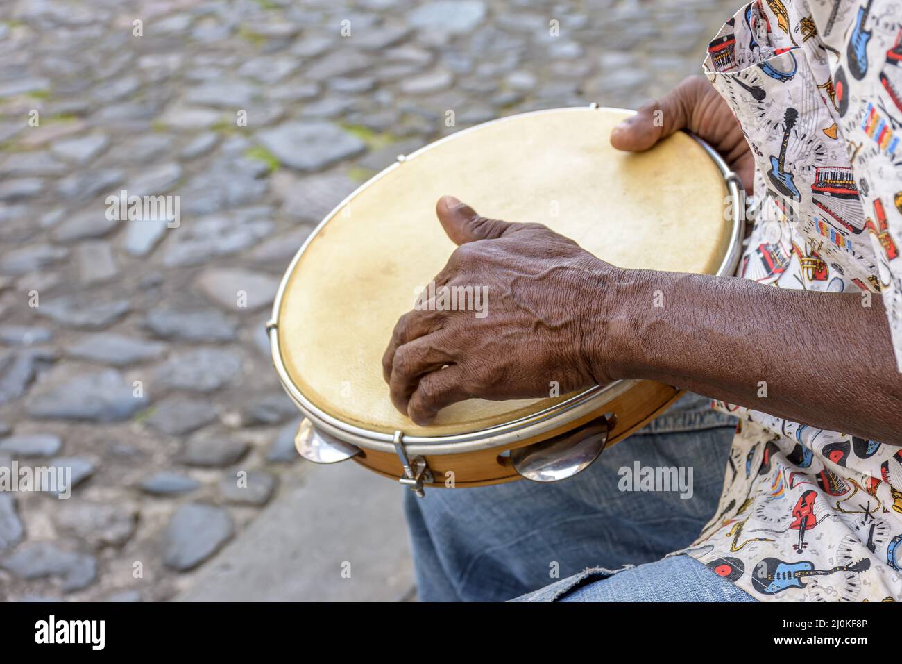 Exécution de Samba avec des mains de musicien jouant du tambourin dans les rues de la ville de Salvador Banque D'Images