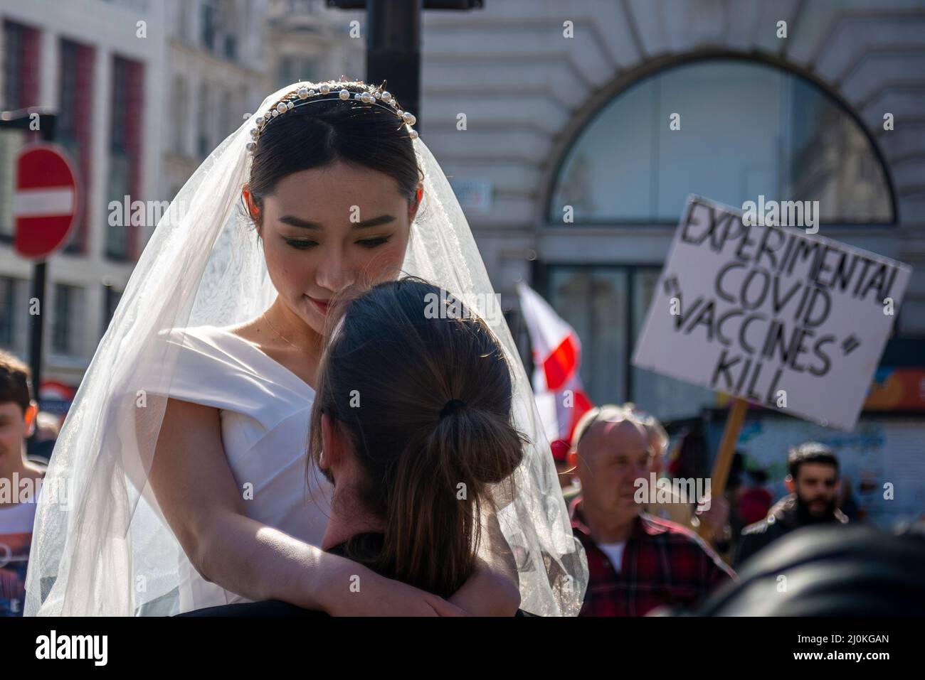 Une manifestation contre la vaccination des enfants contre Covid 19, rejointe par des anti-vaxxers, interrompant un photoshoot de mariage avec une épouse asiatique ignorant Banque D'Images