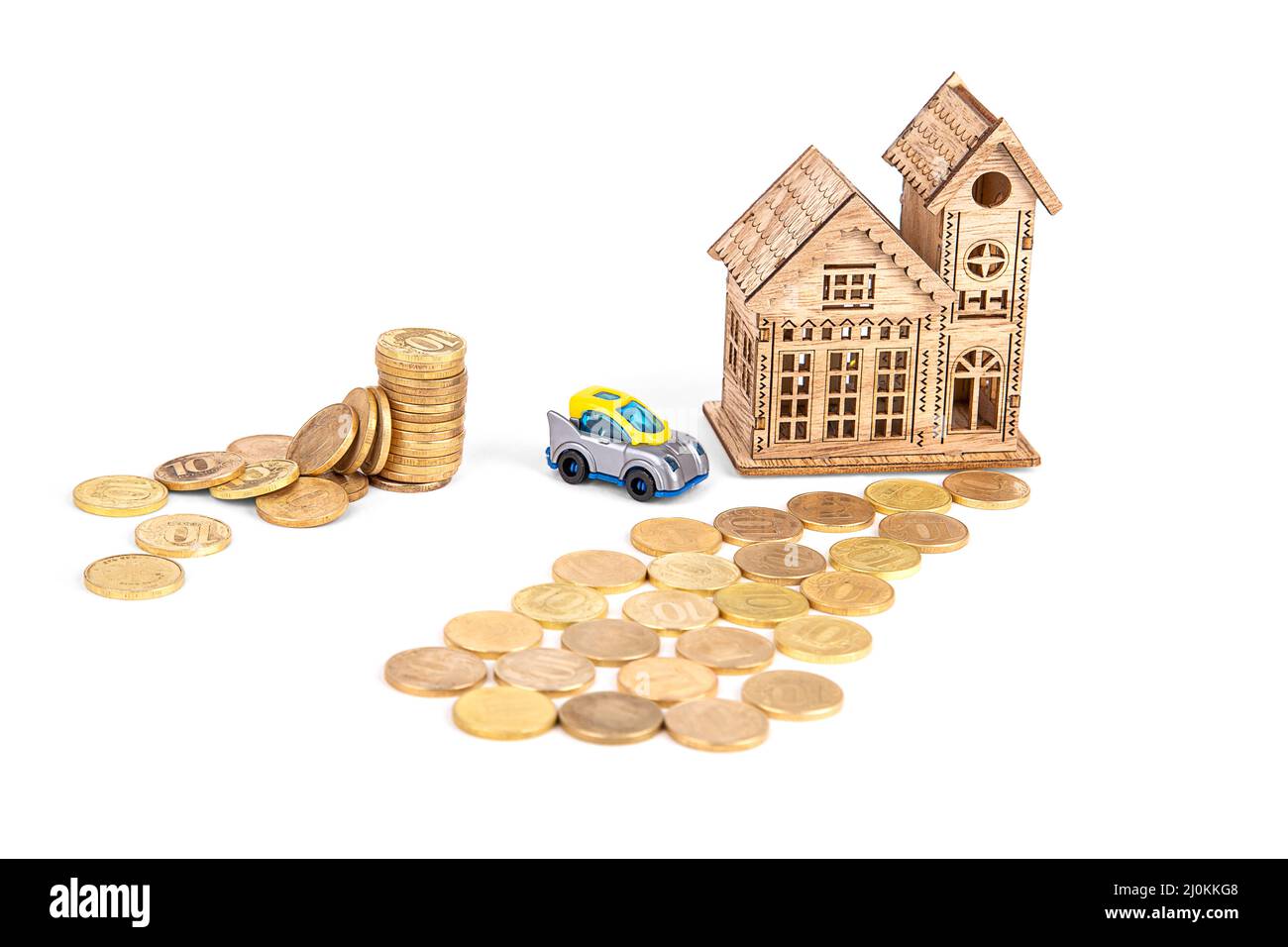 une maison en bois, une route en argent, une voiture et une pile de pièces sur fond blanc Banque D'Images
