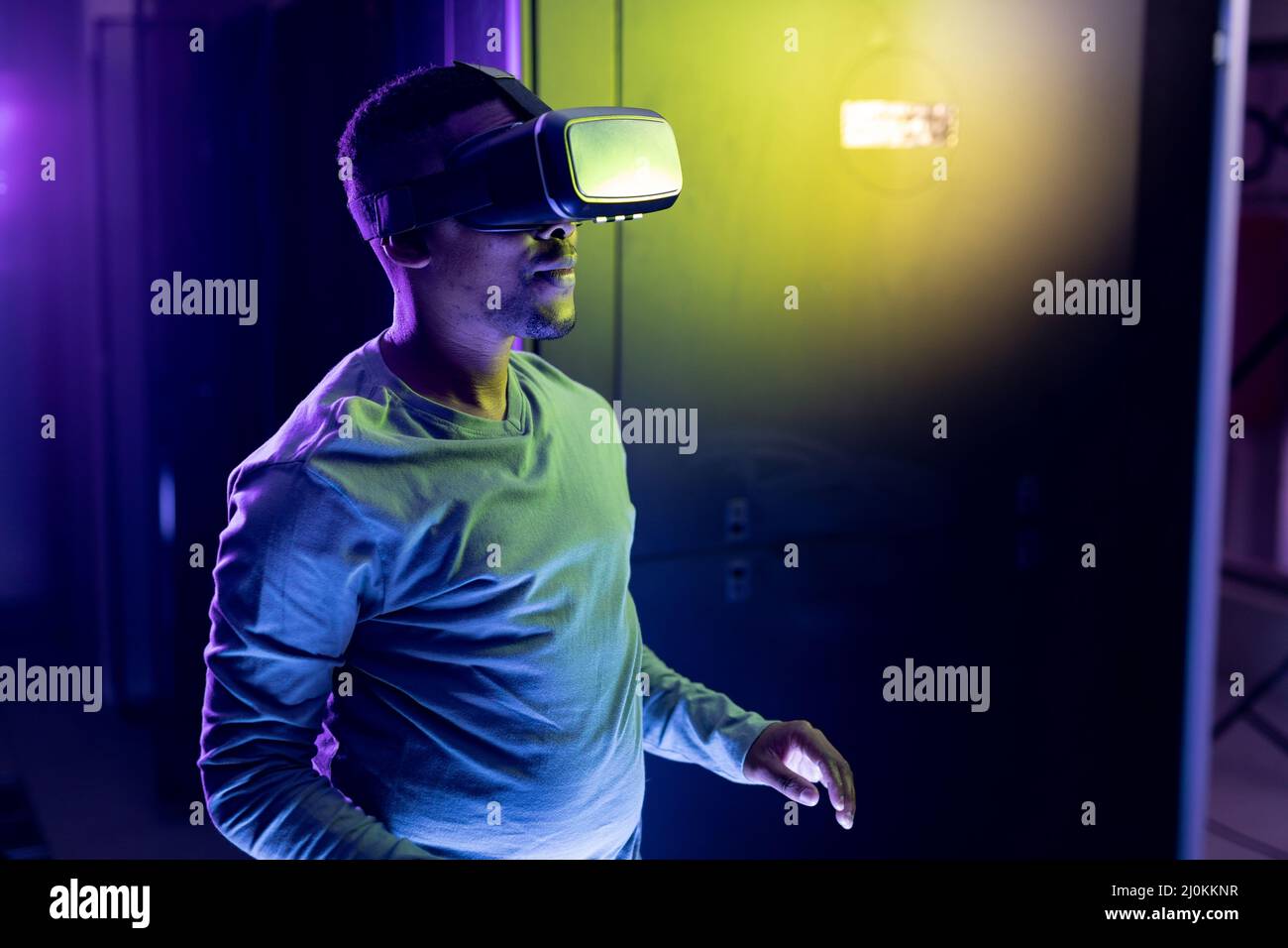 Un technicien informatique afro-américain portant un casque vr et travaillant dans une salle de serveurs Banque D'Images