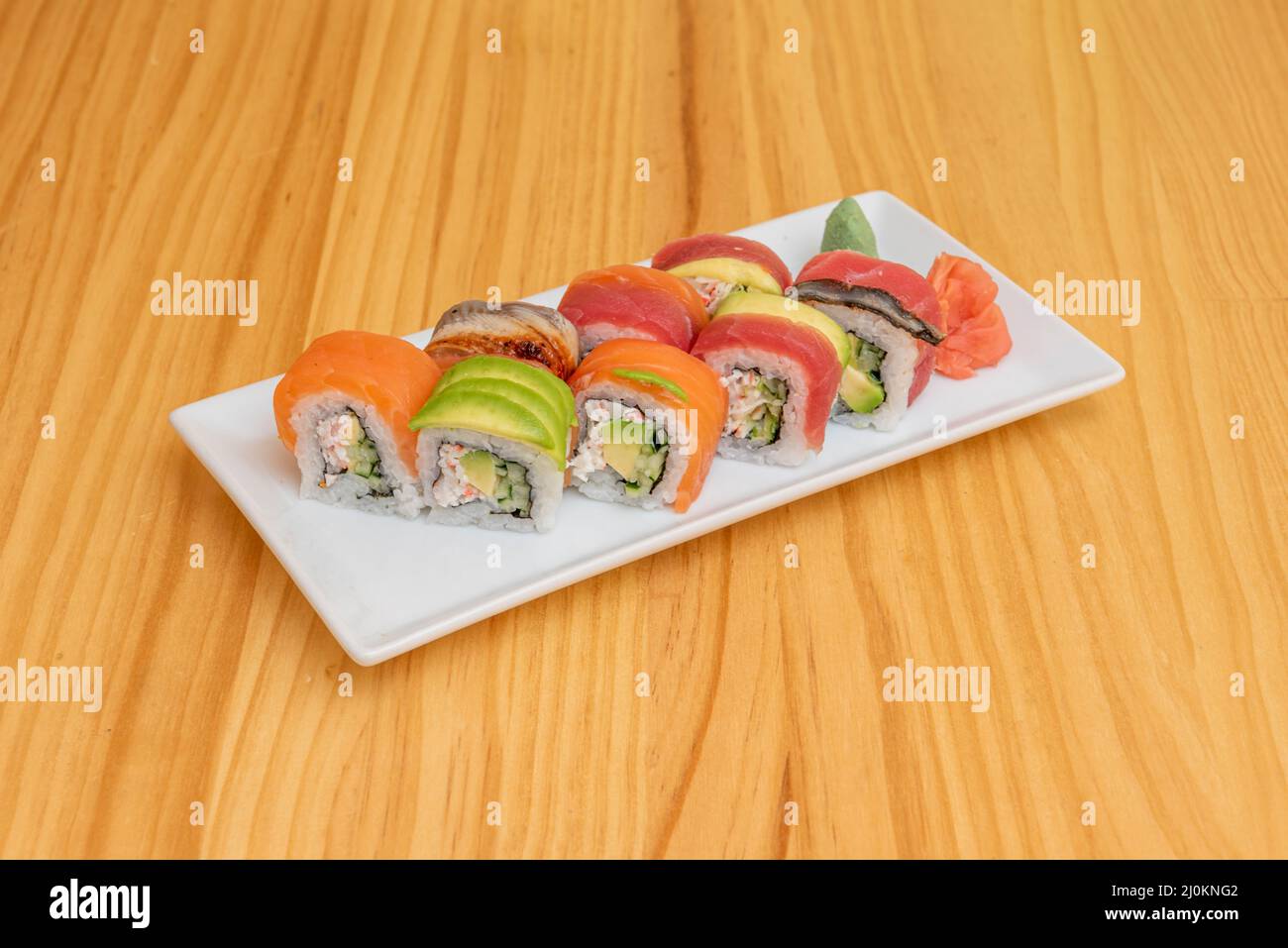 Le rouleau Rainbow est un rouleau de sushi uramaki farci de concombre, d'avocat et de bâtonnets de crabe. Il est préparé avec différents types de poissons, le plus souvent le thon, le salm Banque D'Images