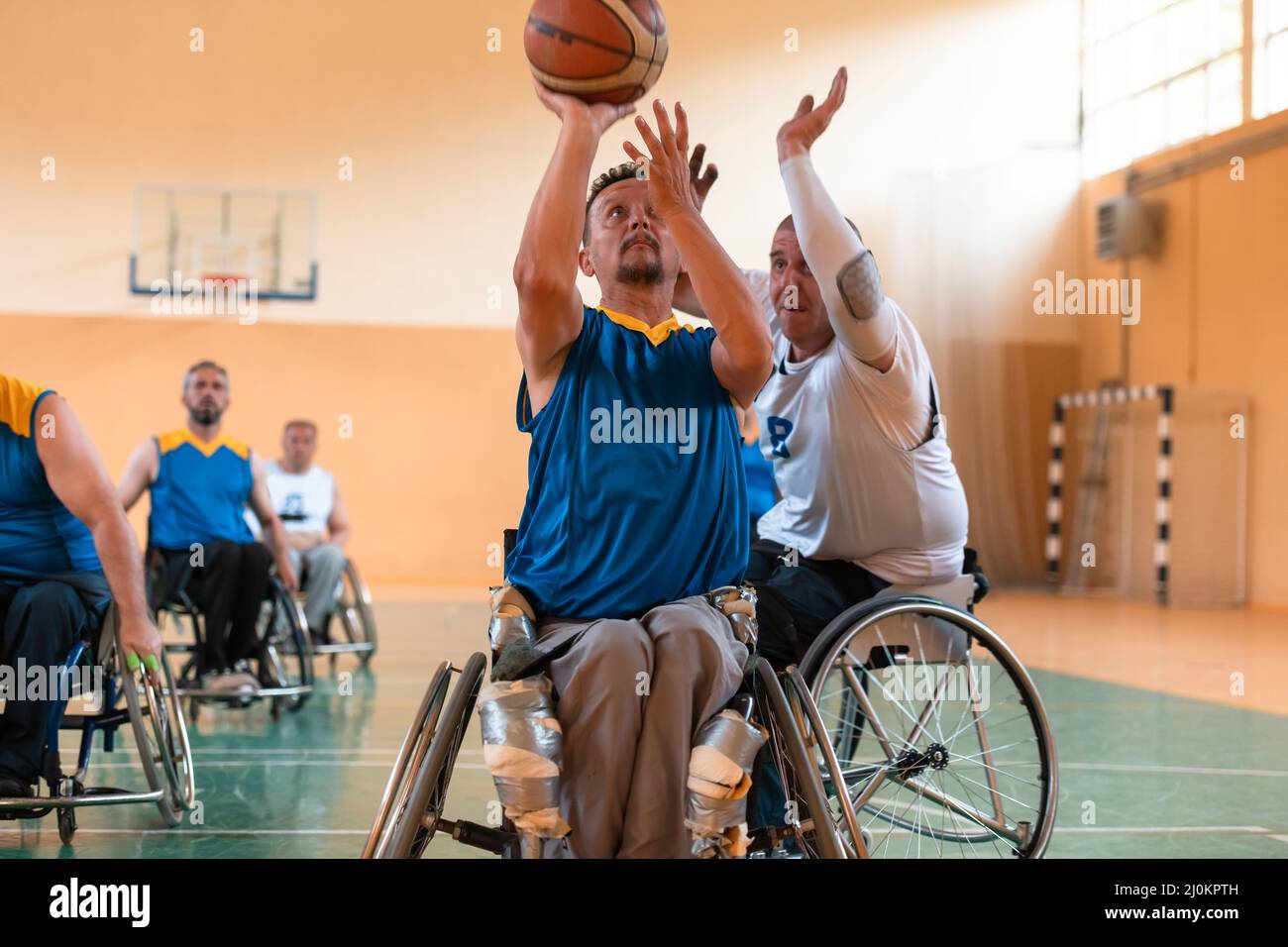 Les vétérans handicapés de la guerre ont mélangé des équipes de basket-ball de race et d'âge en fauteuil roulant et ont joué à un match d'entraînement dans une salle de sport. Handicap Banque D'Images