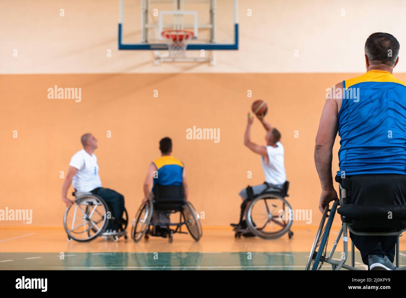 Les vétérans handicapés de la guerre ont mélangé des équipes de basket-ball de race et d'âge en fauteuil roulant et ont joué à un match d'entraînement dans une salle de sport. Handicap Banque D'Images