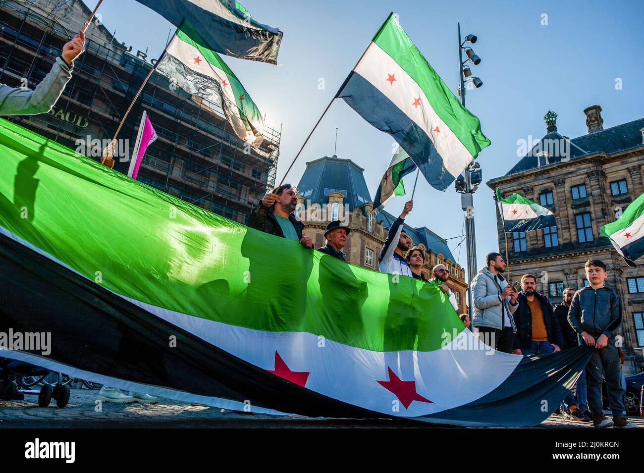 Le peuple syrien est vu arborer un grand drapeau syrien pendant la manifestation. En mars 2011, après quatre décennies de dictature, le peuple syrien s'est levé pacifiquement pour réclamer la démocratie et la dignité. Le régime de Bachar el-Assad a écrasé ce soulèvement par la force, déclenchant une guerre internationale qui a tué plus de 500 000 personnes et chassés 12 millions de leurs foyers. Onze ans après, à Amsterdam, le peuple syrien s'est rassemblé sur la place du Dam pour continuer à exiger leurs droits légitimes, leur liberté et une Syrie pacifique. (Photo par Ana Fernandez/SOPA Images/Sipa USA) Banque D'Images
