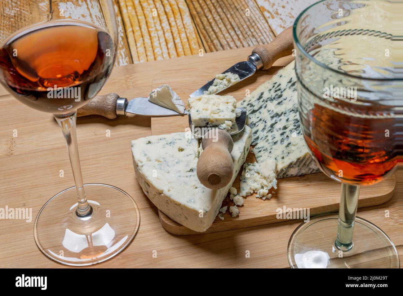 Fromages bleus tranchés et tranchés avec couteaux à fromage et verres de vin de Claret espagnol Banque D'Images