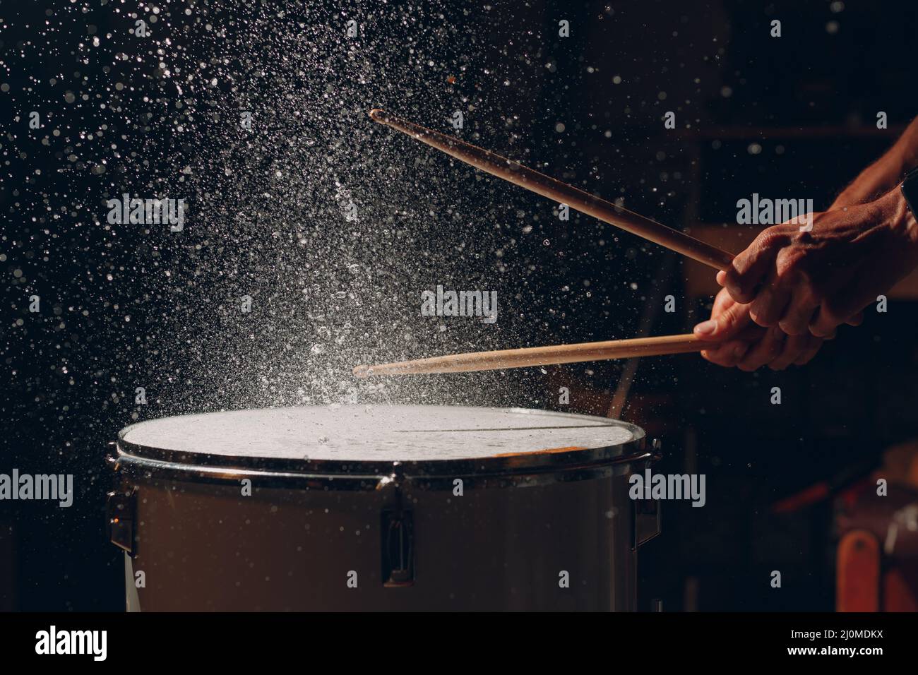 Bâtonnets de batterie rythme de rythme de rythme sur la surface du tambour avec gouttes d'eau Banque D'Images