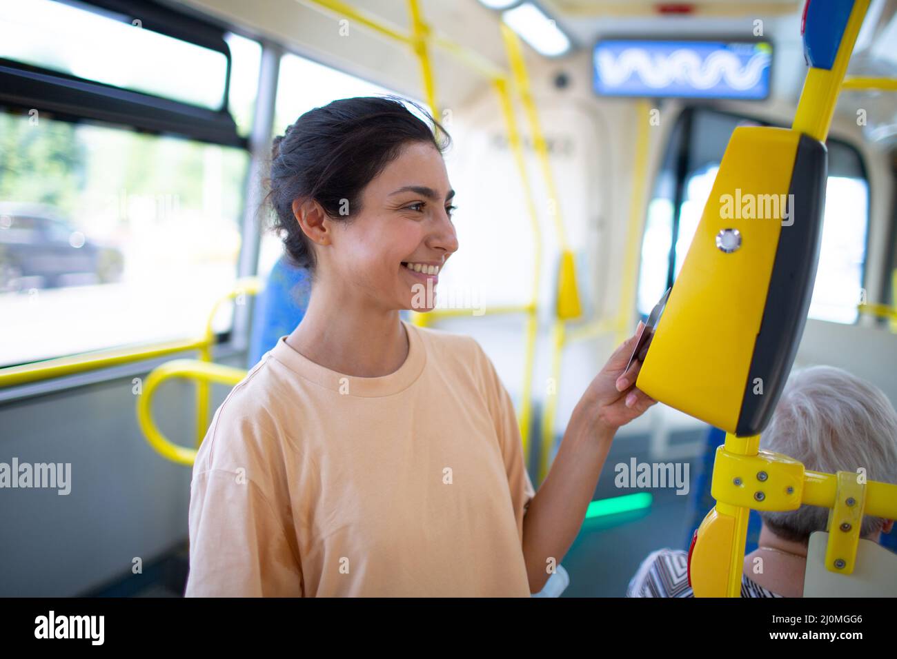 Femme de payer conctactless avec smartphone pour le transport public dans le tram Banque D'Images