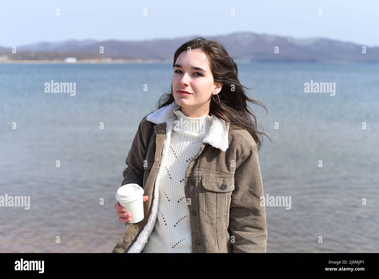 Au printemps, une jeune femme russe boit du café contre la mer japonaise Banque D'Images