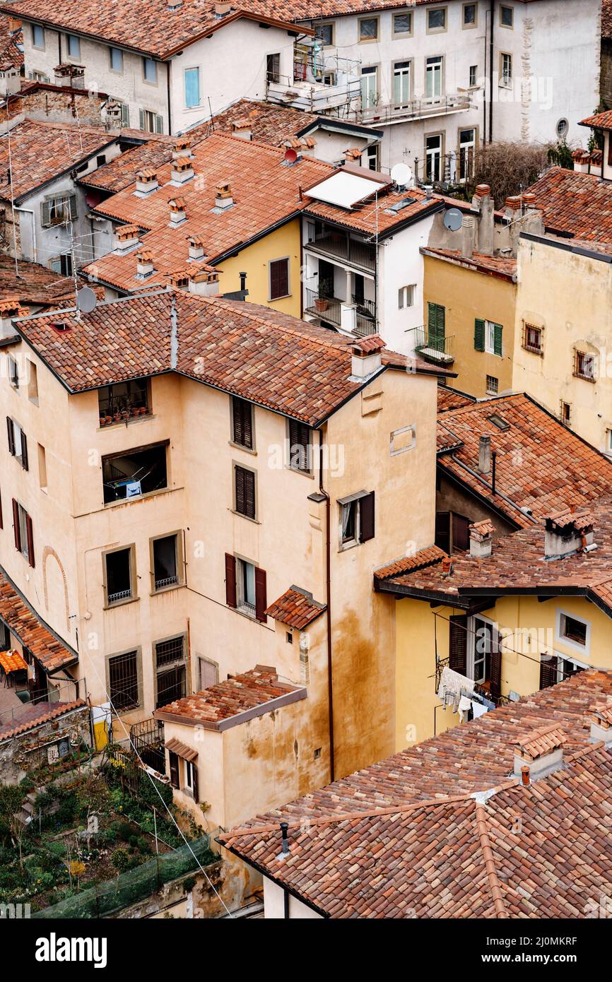 Cheminées sur les toits de tuiles rouges des vieilles maisons.Bergame, Italie Banque D'Images
