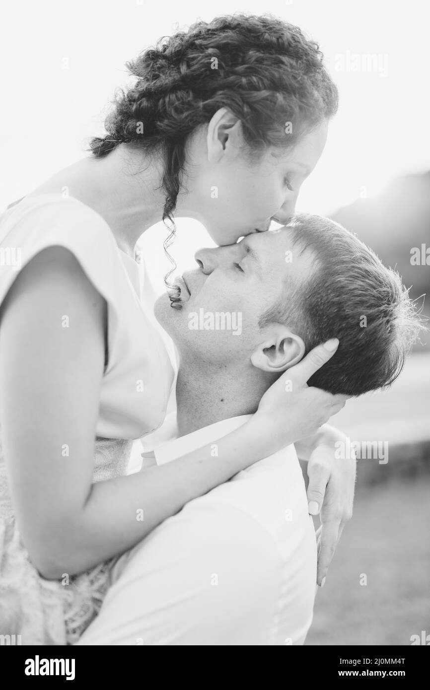 Kotor, Monténégro - 21.06.17: Une femme embrasse un homme sur le front, embrassant son cou avec ses mains. Photo en noir et blanc. Fermer- Banque D'Images