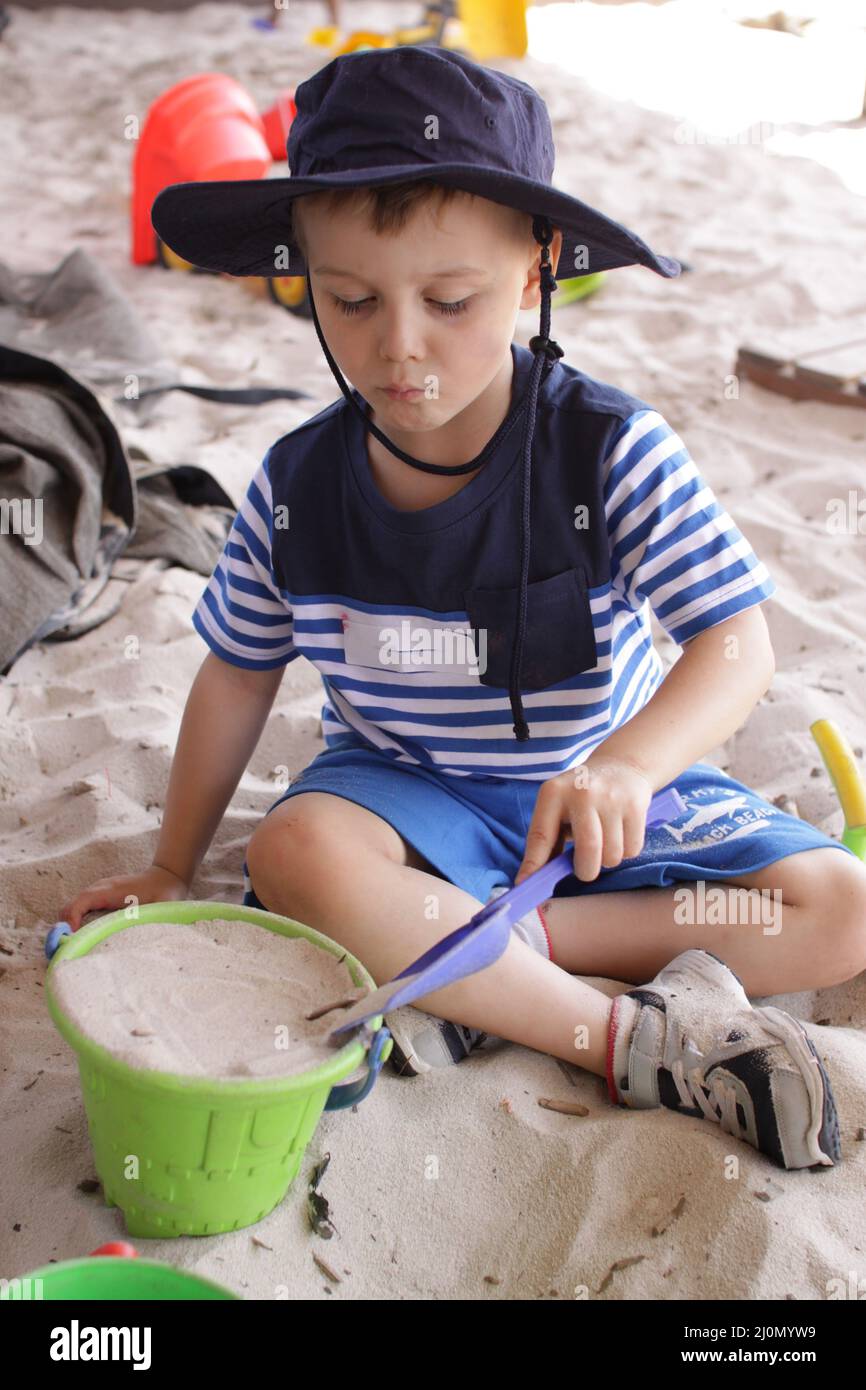 Un jeune garçon jouant dans le bac à sable à l'école Banque D'Images