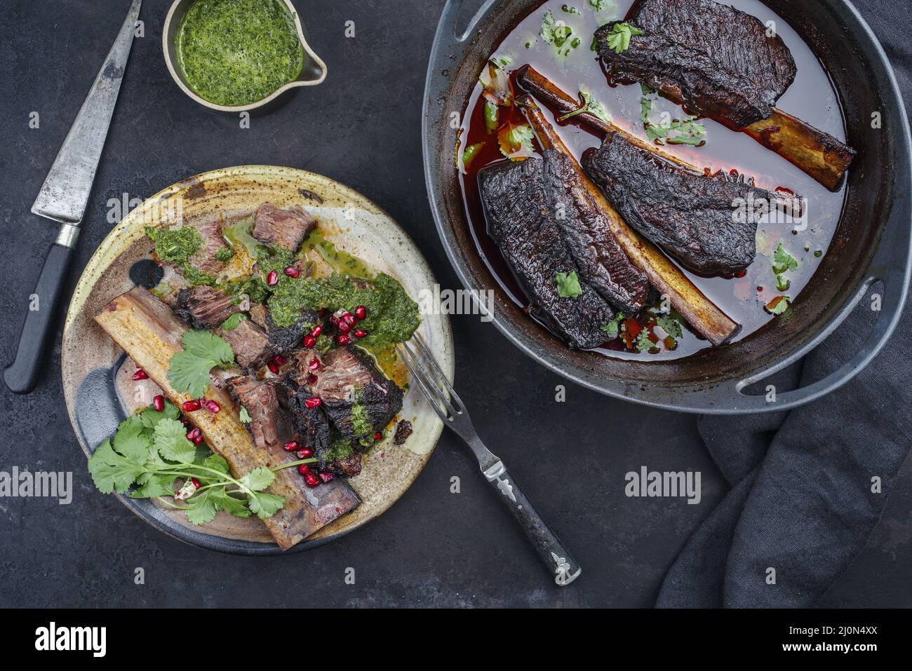 Côtelettes de bœuf braisées traditionnelles à la sauce au vin rouge servies en gros plan dans un four hollandais au design moderne Banque D'Images