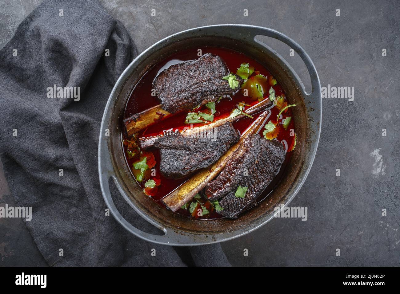 Côtelettes de bœuf braisées traditionnelles dans une sauce au vin rouge servi comme vue de dessus dans un four hollandais de conception moderne Banque D'Images