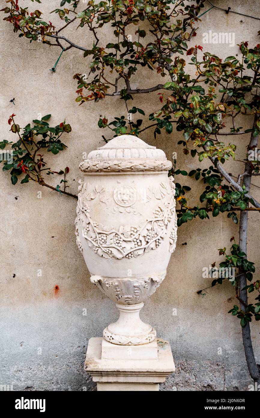 Vase en pierre avec motifs sur le fond d'un mur.Villa Monastero, Italie Banque D'Images