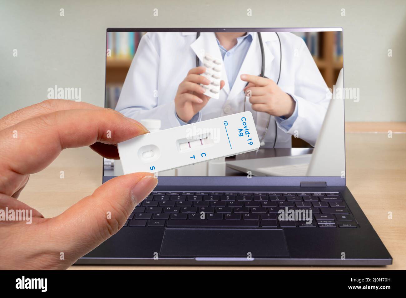 Main mâle tenant un kit de test rapide d'antigène COVID-19 avec deux lignes rouges indiquant un positif. Banque D'Images
