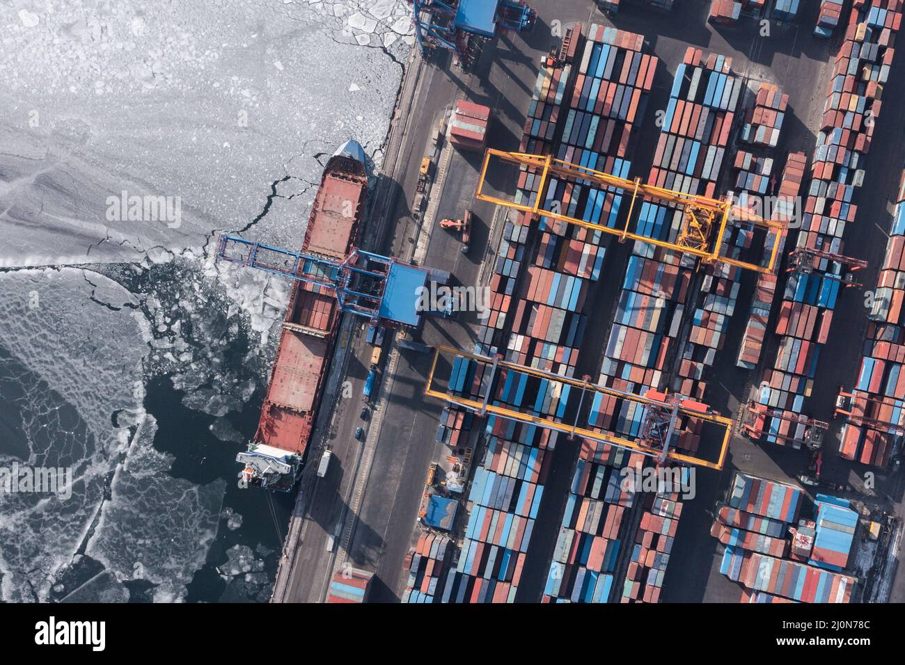 Vladivostok, Russie - 27 janvier 2022 : Vue de dessus du terminal des conteneurs du port maritime. En hiver, un bateau à conteneurs est en train de charger au quai. Banque D'Images