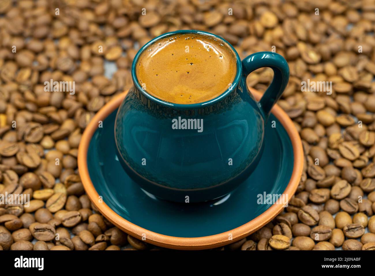 Café turc dans une tasse rustique. Arrière-plan des grains de café. Gros plan Banque D'Images