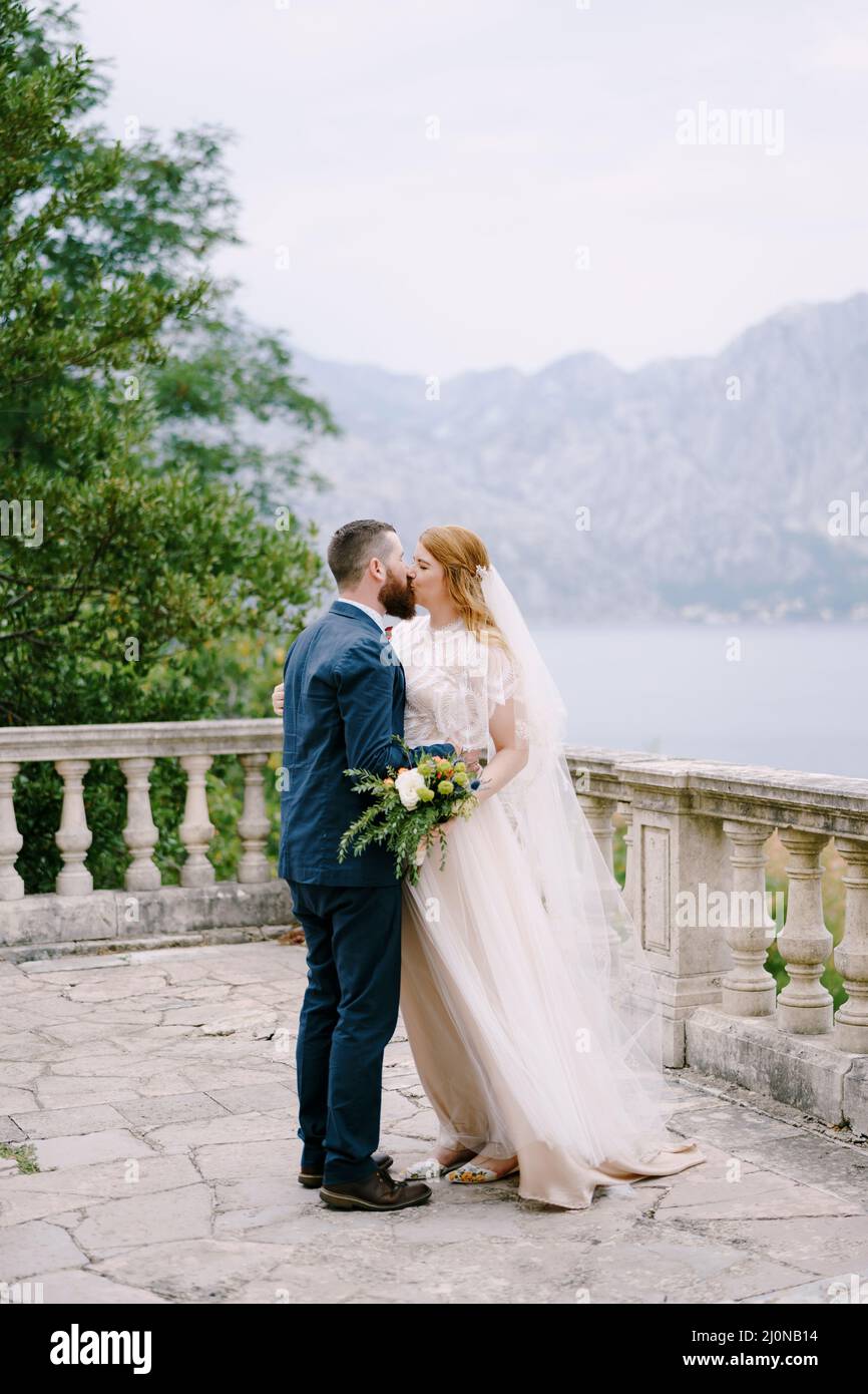 Mariée embrasse marié sur la terrasse en pierre sur le fond de la mer Banque D'Images