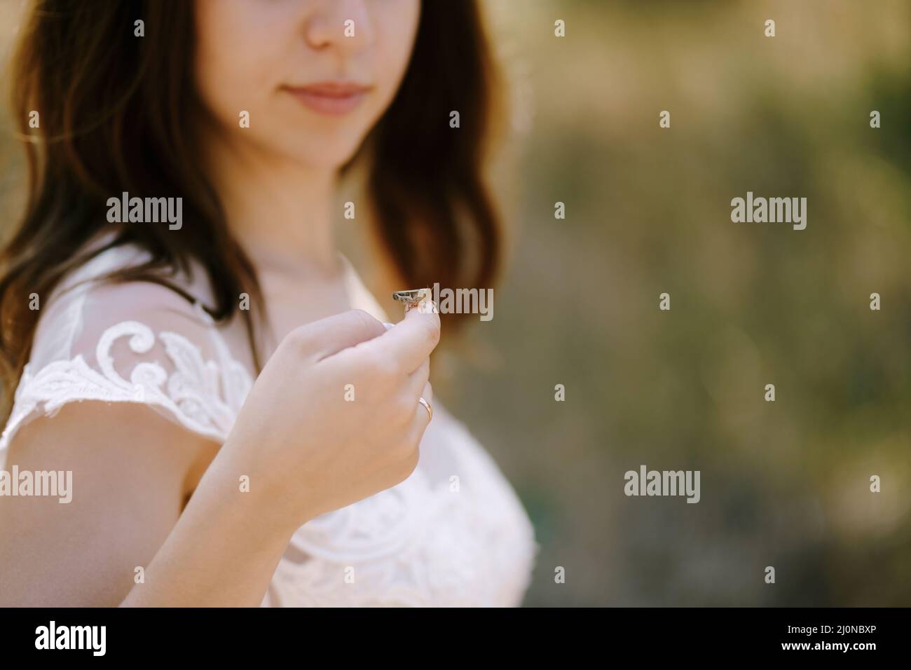 Mariée dans une robe blanche tient une sauterelle sur la main.Portrait Banque D'Images