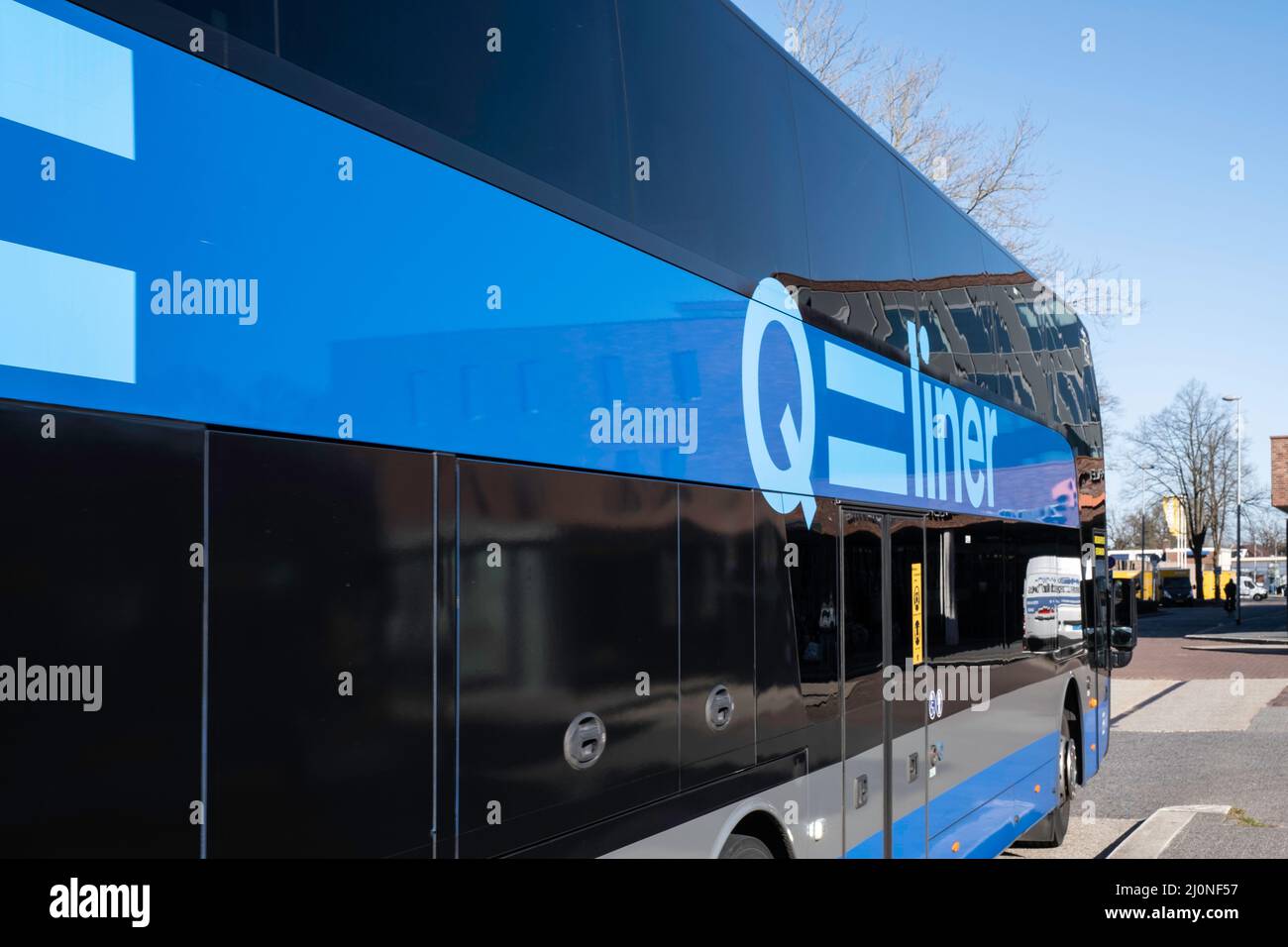 Vue latérale de l'arrivée du bus bleu Qliner à la gare de la ville néerlandaise d'Emmen. Qliner est un système de bus express utilisé dans les transports en commun Banque D'Images