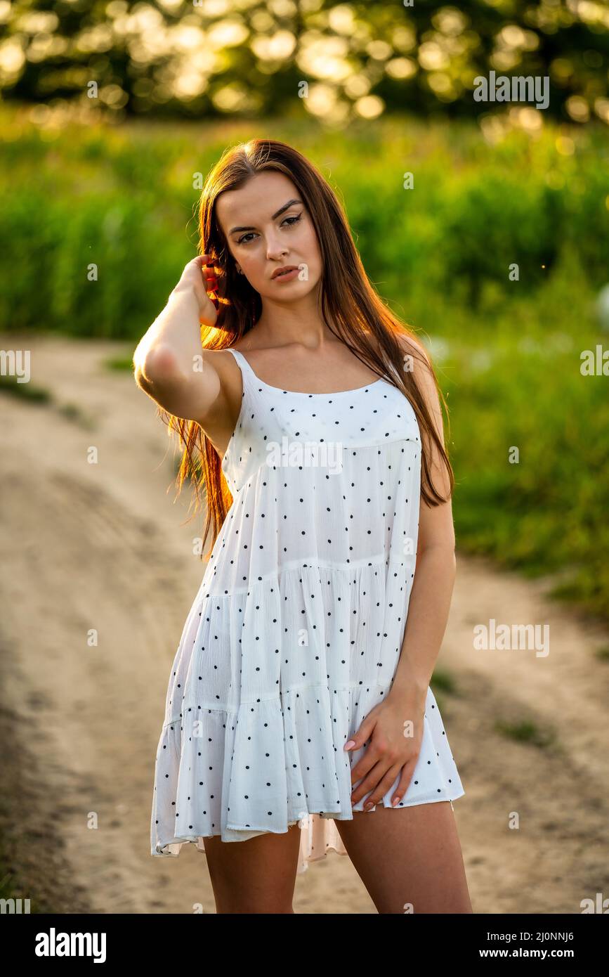 Jeune belle femme en robe blanche dans champ de maïs. Banque D'Images