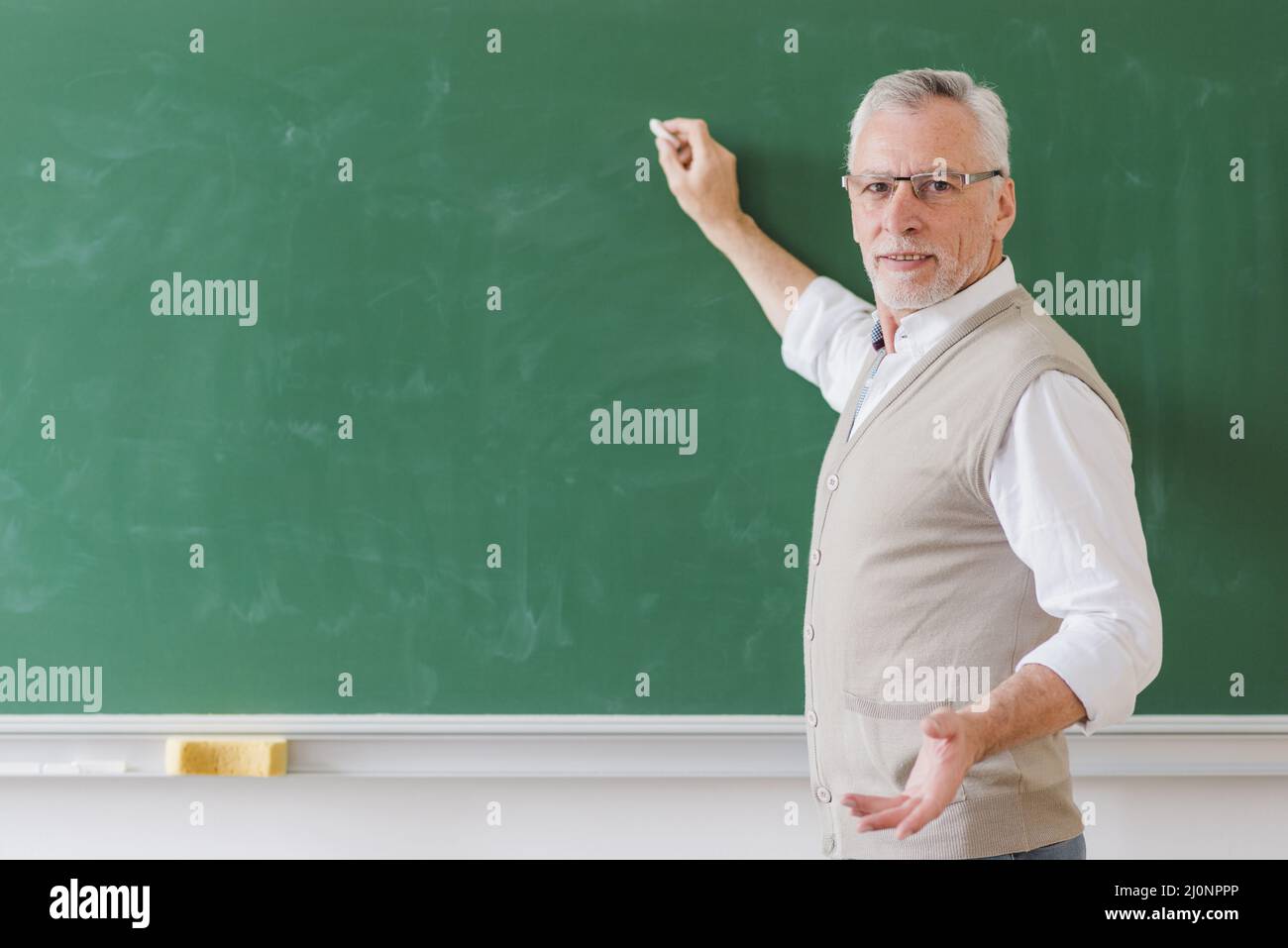 Professeur principal masculin expliquant l'écriture de tableau vert . Haute qualité et résolution magnifique concept de photo Banque D'Images