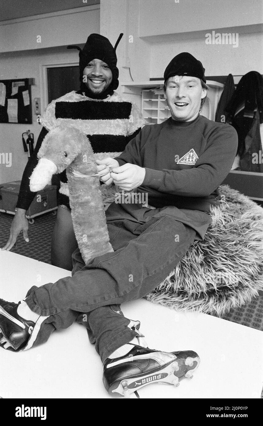 West Bromwich Albion Players, Cyrille Regis et Derek Statham portant des costumes habillés de fantaisie dans la salle d'habillage, 26th octobre 1983. Les joueurs de WBA savent tout sur les oiseaux et les abeilles. L'Angleterre internationale Cyrille a certainement une piqûre dans sa queue. Car il est bien connu pour faire voler des plumes dans la défense de l'opposition quand il bourdonne autour en vue du but. Mais le coéquipier Derek ne pouvait pas être accusé d'enterrer sa tête dans le sable - ou d'obtenir ses jambes dans une torsion. Pour le défenseur Albion espère bientôt être de retour sur le terrain après une blessure. Le duo dynamique s'est enjoué un peu de crin lorsqu'il s'est défait Banque D'Images