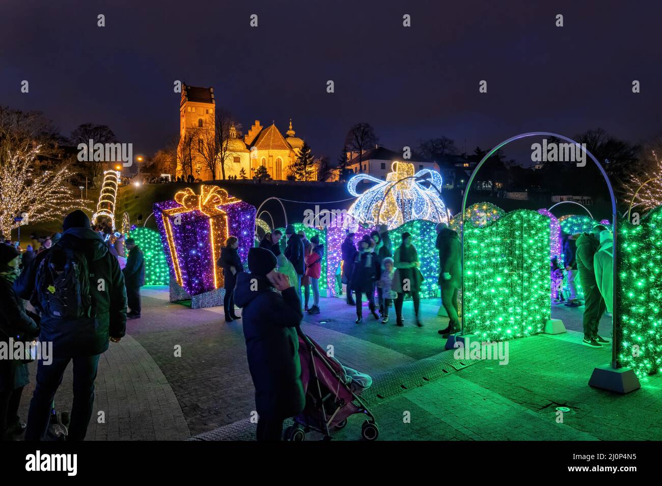 Varsovie, Pologne, les personnes avec des enfants apprécient l'éclairage nocturne de Noël dans le parc de la ville, sous la Nouvelle ville. Banque D'Images