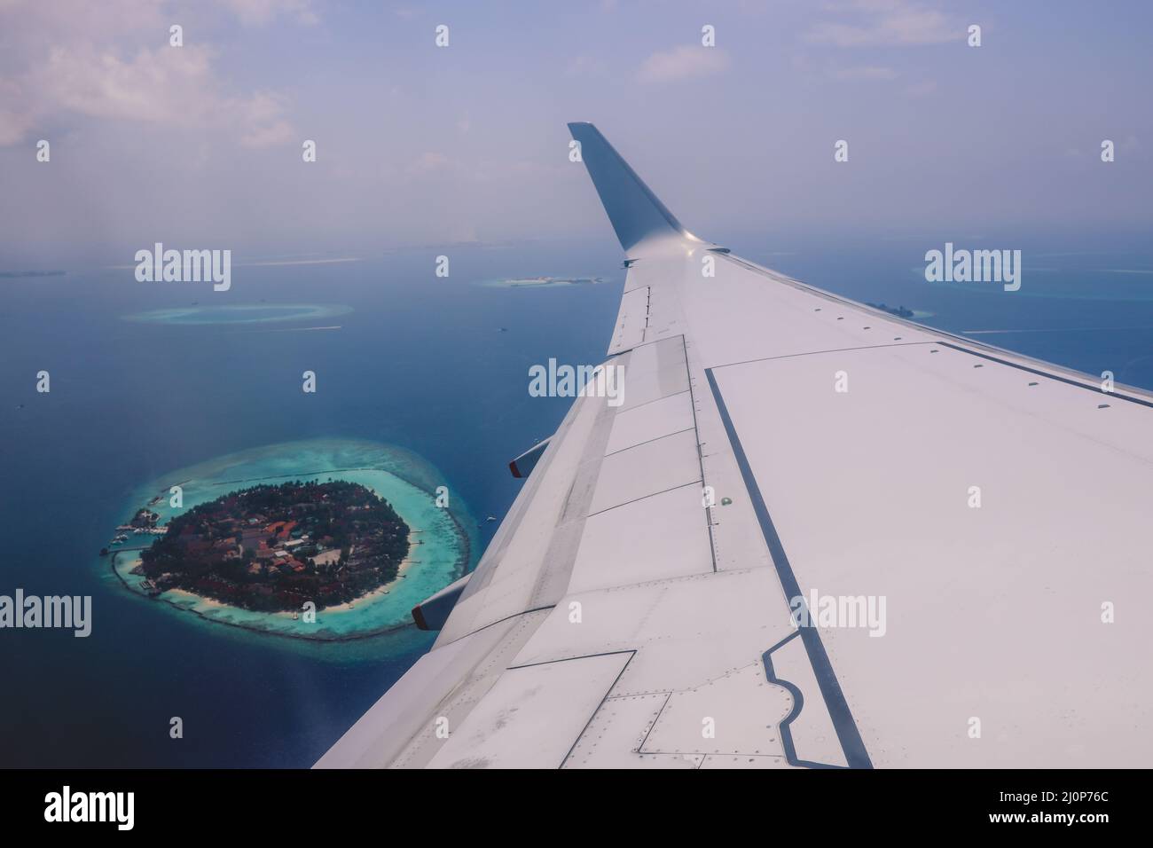 Vue aérienne depuis la fenêtre de l'avion jusqu'à l'île Male au milieu de l'océan Indien bleu, République des Maldives Banque D'Images