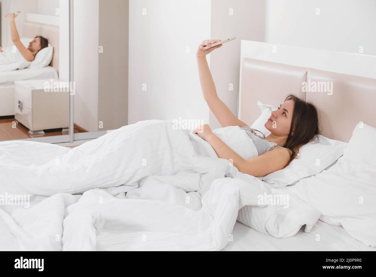 Femme Blogger enregistrement vidéo Vlog sur smartphone à la maison en ligne Influencer sur dans le lit. Copier l'espace. Selfie Banque D'Images