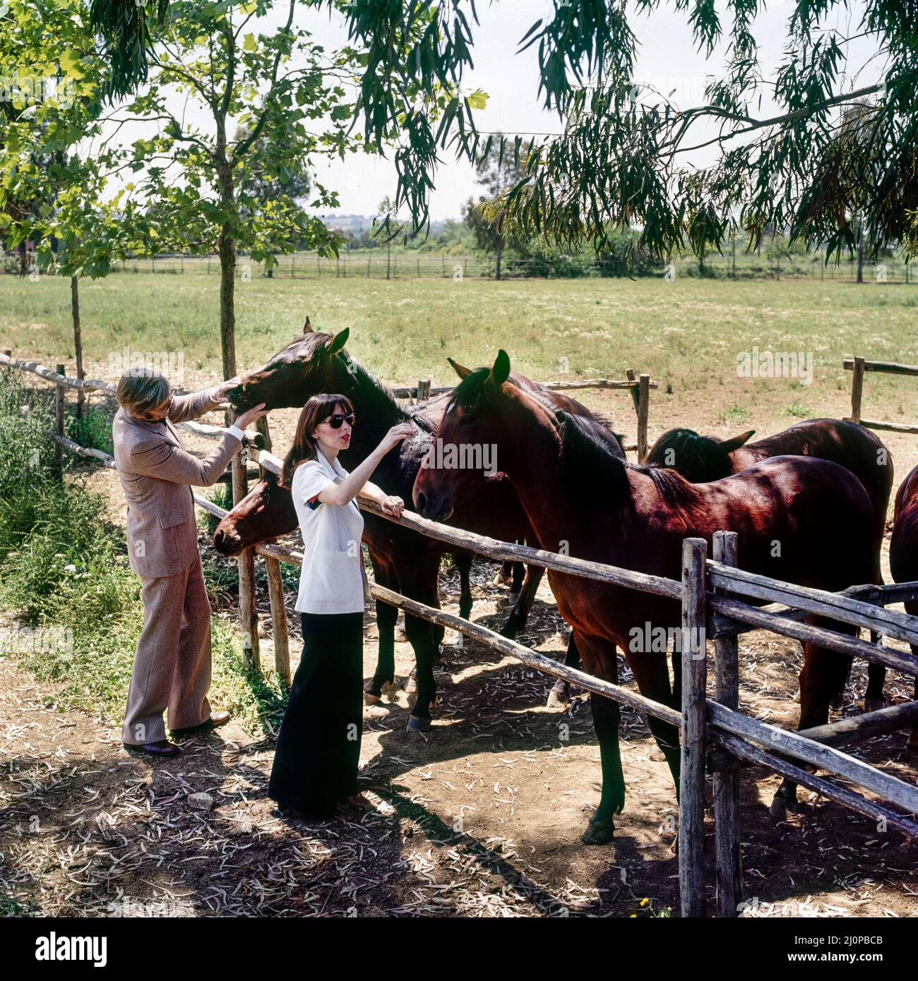 Vintage Italie 1970s, élégant couple d'âge moyen visite l'élevage de chevaux, la campagne romaine ranch, Lazio, Europe, Banque D'Images