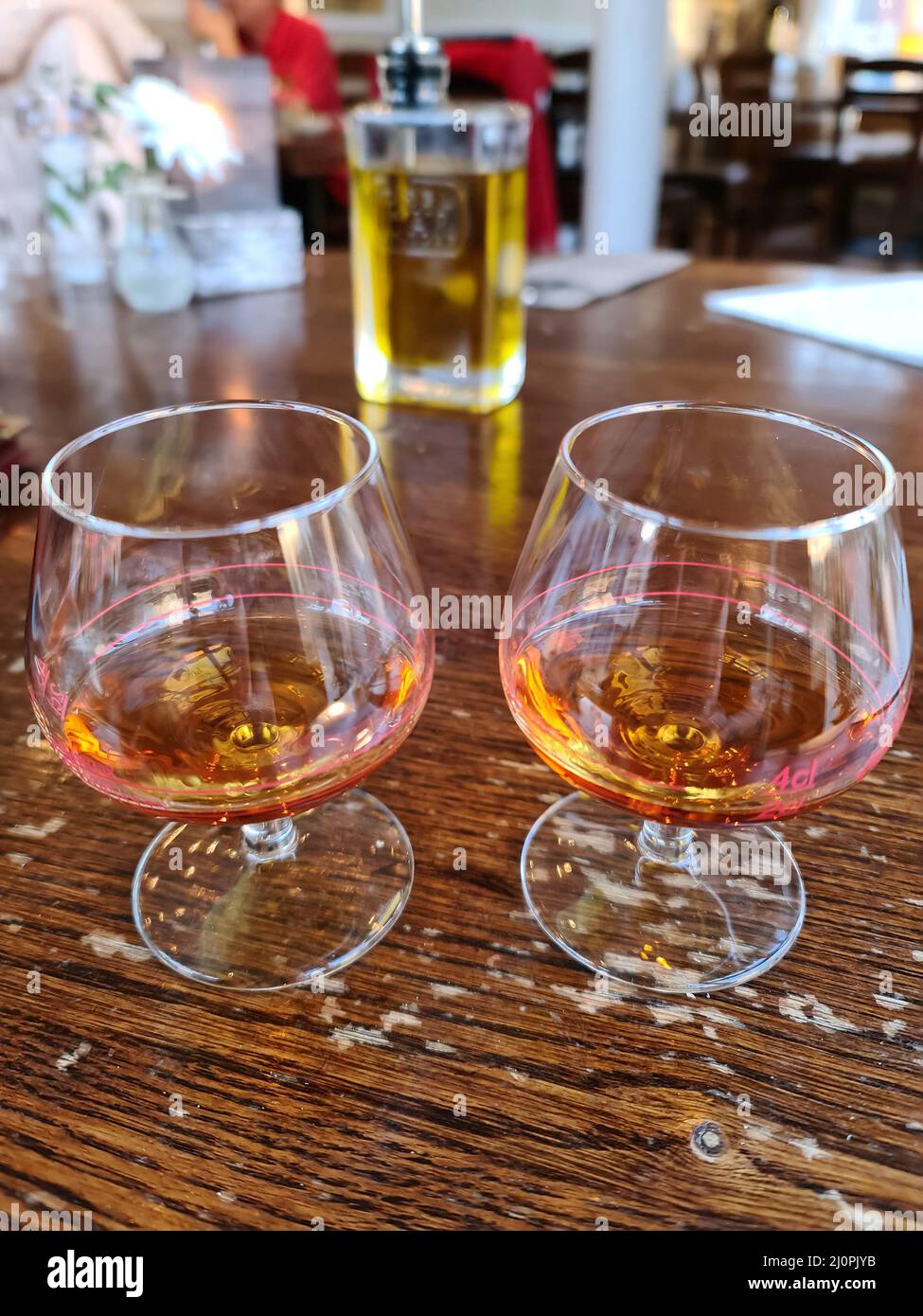 Deux verres d'amaretto sur fond doux sur une table en bois Banque D'Images