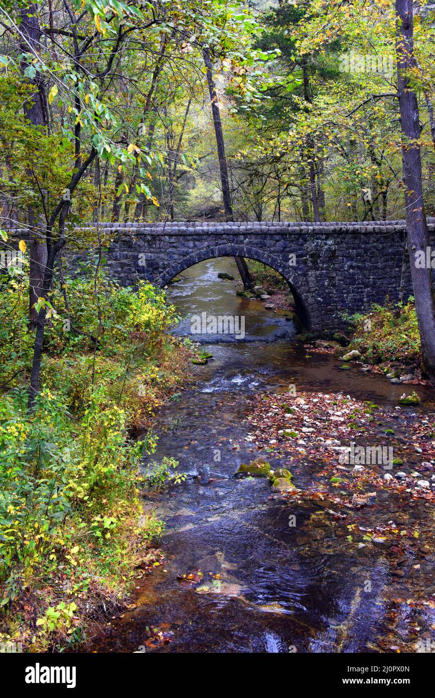 Une scène tranquille dans l'aire de jeux des grottes de Blanchard Springs montre un pont en pierre et demi-lune. North Sylamore Creek coule doucement sous le ar de pierre Banque D'Images