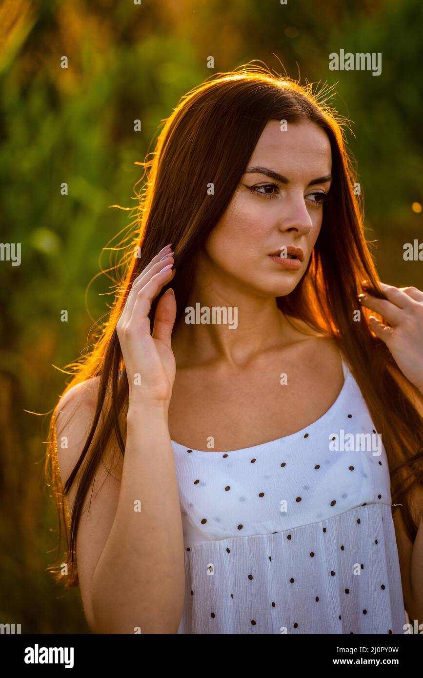 Jeune belle femme en robe blanche dans champ de maïs. Banque D'Images