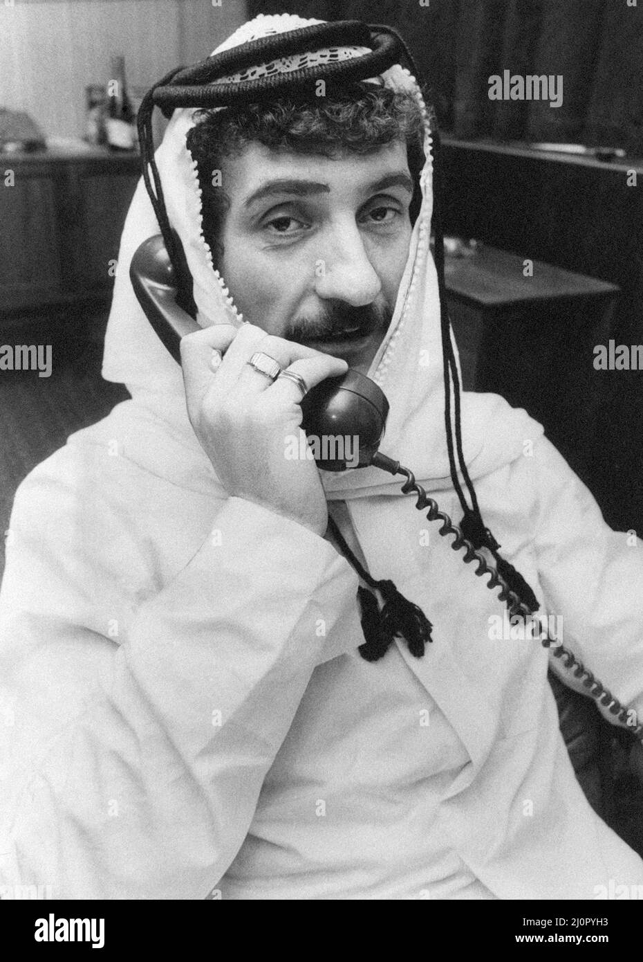 Terry McDermott, habillé comme un cheikh arabe, alors qu'il a fait une blague pratique sur Newcastle United Staff. Il a éclos son complot après avoir lu des rapports selon lesquels Kevin Keegan était recherché par les Arabes fous de foot en Arabie Saoudite. Il est arrivé au terrain d'entraînement Benwell de United et a informé le directeur Arthur Cox qu'il voulait parler des affaires de transfert sur Keegan. Cependant, il n'a pas pris de temps pour que le patron et Keegan coton dessus. Terry a porté la tenue qu'il a précédemment reçue à Dubaï lors de sa tournée avec Liverpool. 21st janvier 1983. Banque D'Images Terry McDermott, habillé comme un cheikh arabe, alors qu'il a fait une blague pratique sur Newcastle United Staff. Il a éclos son complot après avoir lu des rapports selon lesquels Kevin Keegan était recherché par les Arabes fous de foot en Arabie Saoudite. Il est arrivé au terrain d'entraînement Benwell de United et a informé le directeur Arthur Cox qu'il voulait parler des affaires de transfert sur Keegan. Cependant, il n'a pas pris de temps pour que le patron et Keegan coton dessus. Terry a porté la tenue qu'il a précédemment reçue à Dubaï lors de sa tournée avec Liverpool. 21st janvier 1983. Banque D'Images