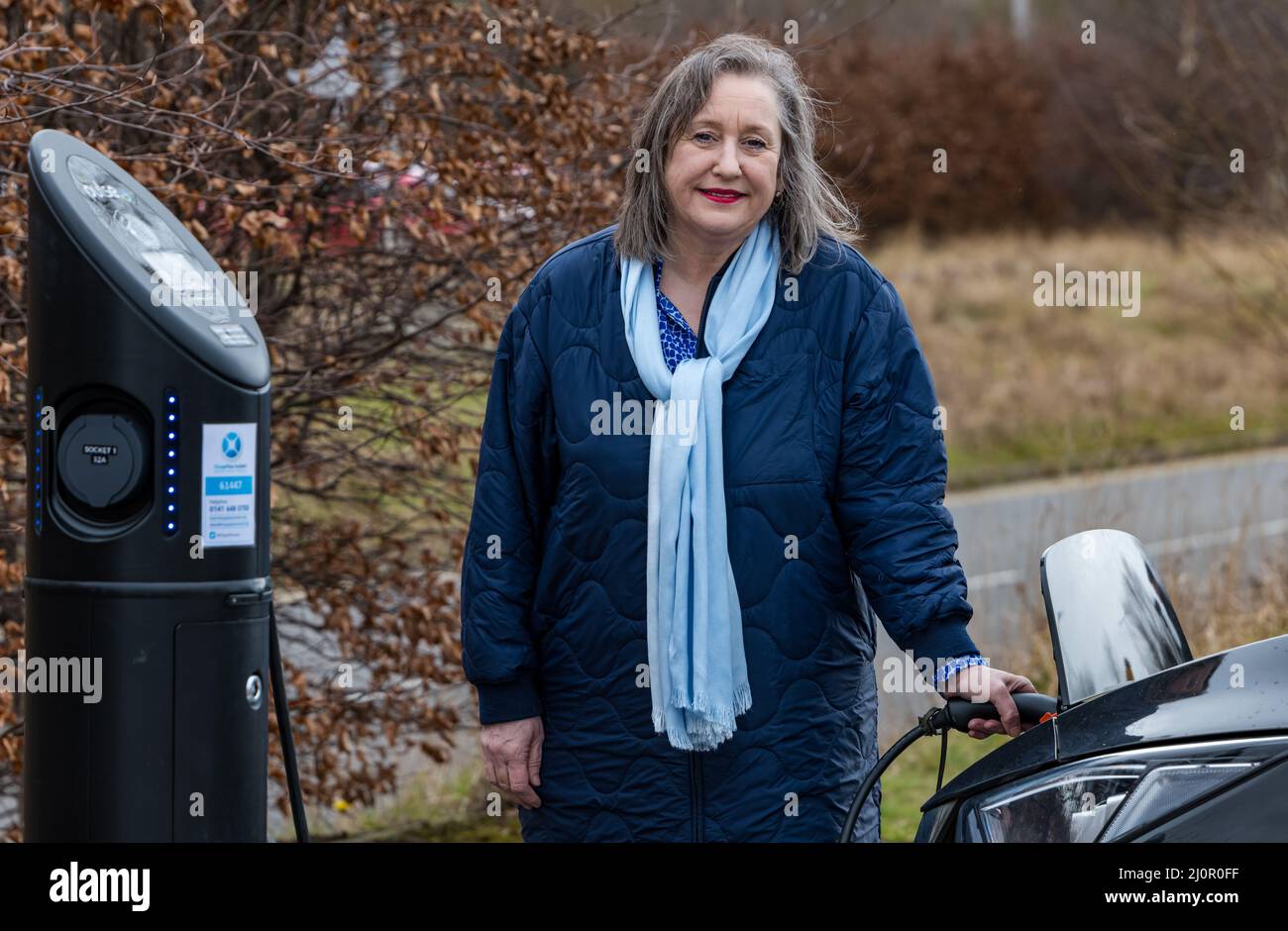 Lesley MacInnes, conseillère du SNP et responsable des transports, fait la démonstration du nouveau point de recharge pour voiture électrique, Ingliston Park and Ride, Édimbourg, Écosse, Royaume-Uni Banque D'Images