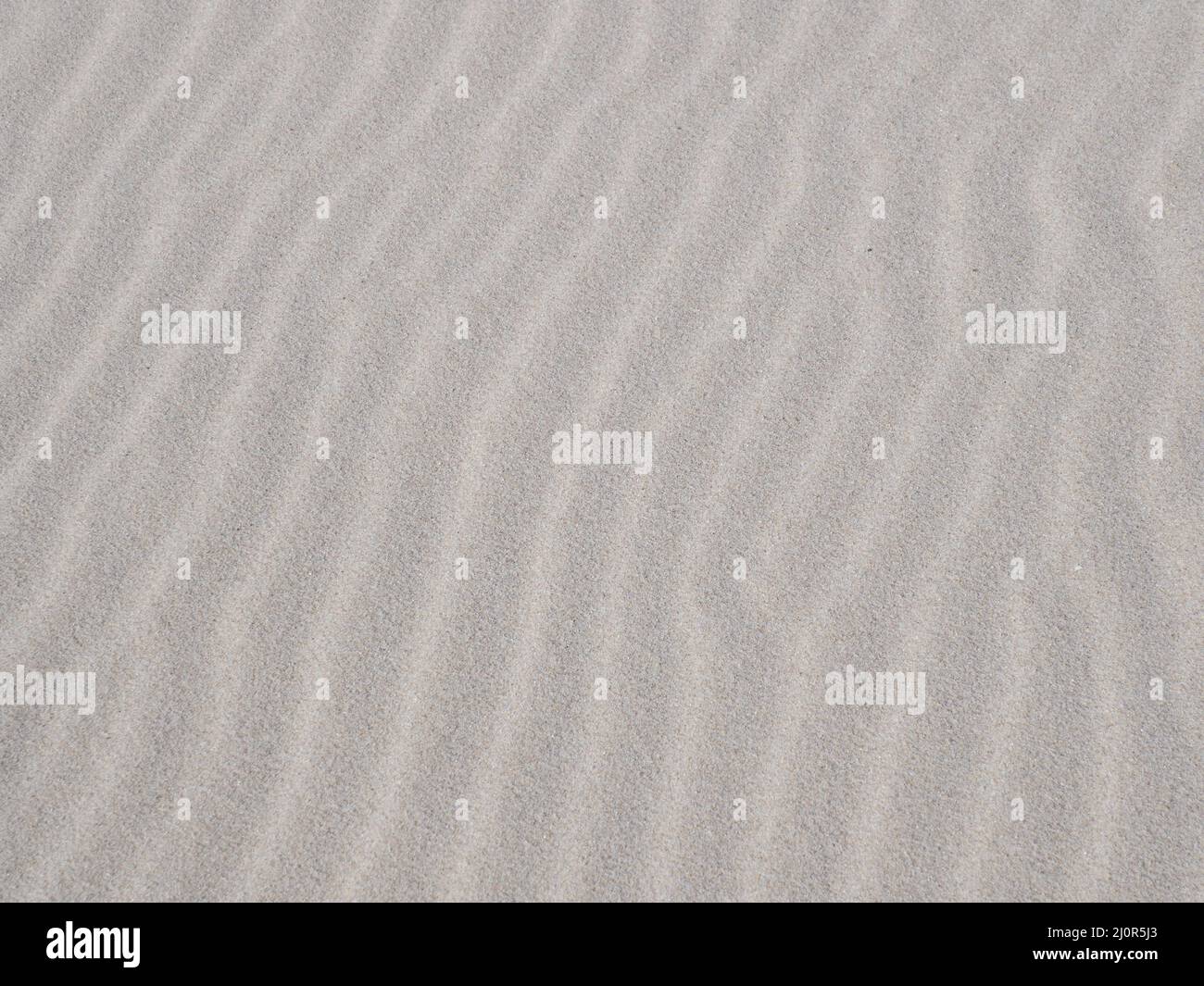 Motif de texture d'arrière-plan de sable blanc ondulé et ondulé Banque D'Images