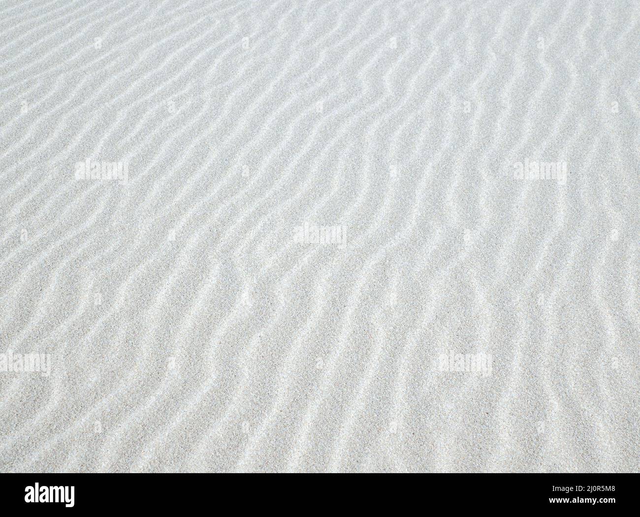 Motif de texture d'arrière-plan de sable blanc ondulé et ondulé Banque D'Images