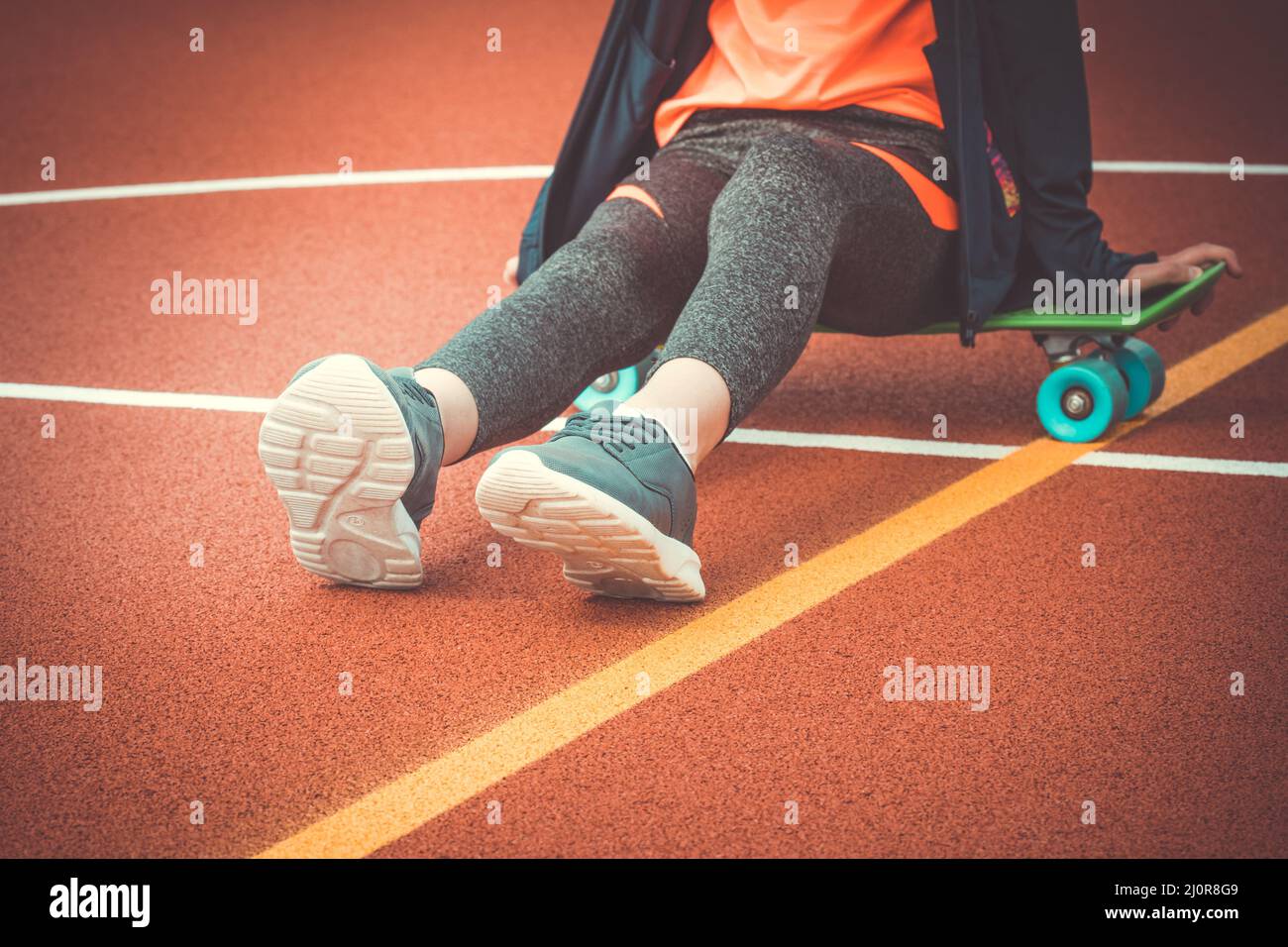 Fille assise sur un panneau de penny Banque D'Images