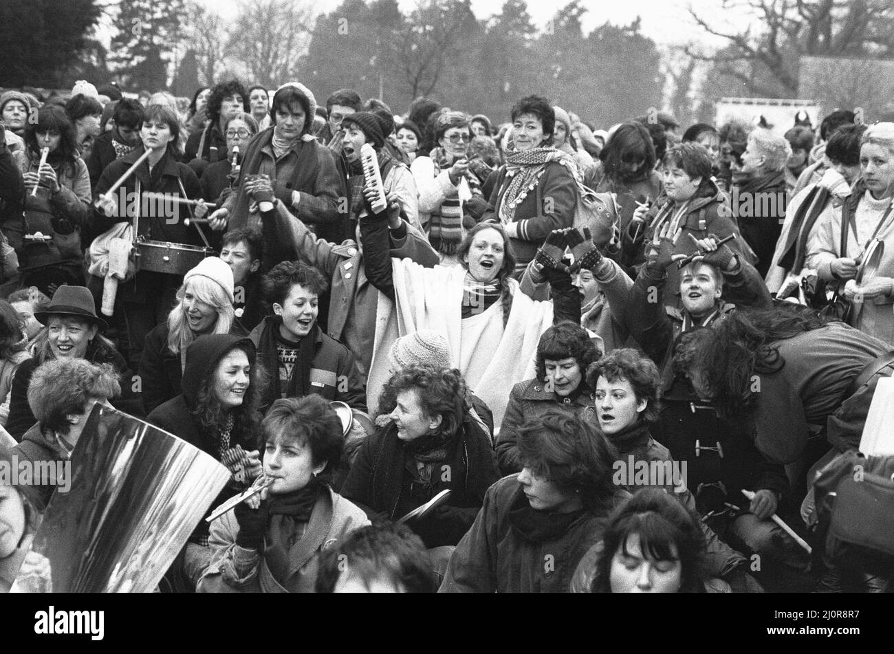 50 000 femmes convergent vers le « camp de la paix des femmes » de Greenham Common pour relier les mains et encercler la base aérienne américaine pour protester contre la décision d'y mettre des missiles de croisière américains. Nos spectacles photo : des femmes protestataires s'assoient sur la route pour bloquer l'une des portes de la base aérienne le 12th décembre 1983 Banque D'Images