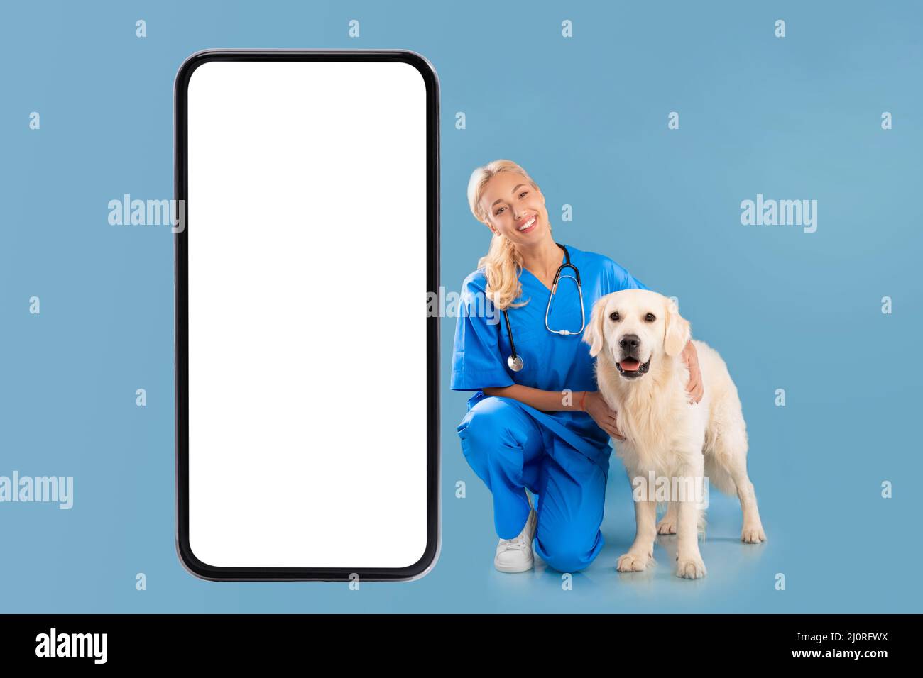 Infirmière posant avec le chien près de l'écran géant de la cellule blanche Banque D'Images