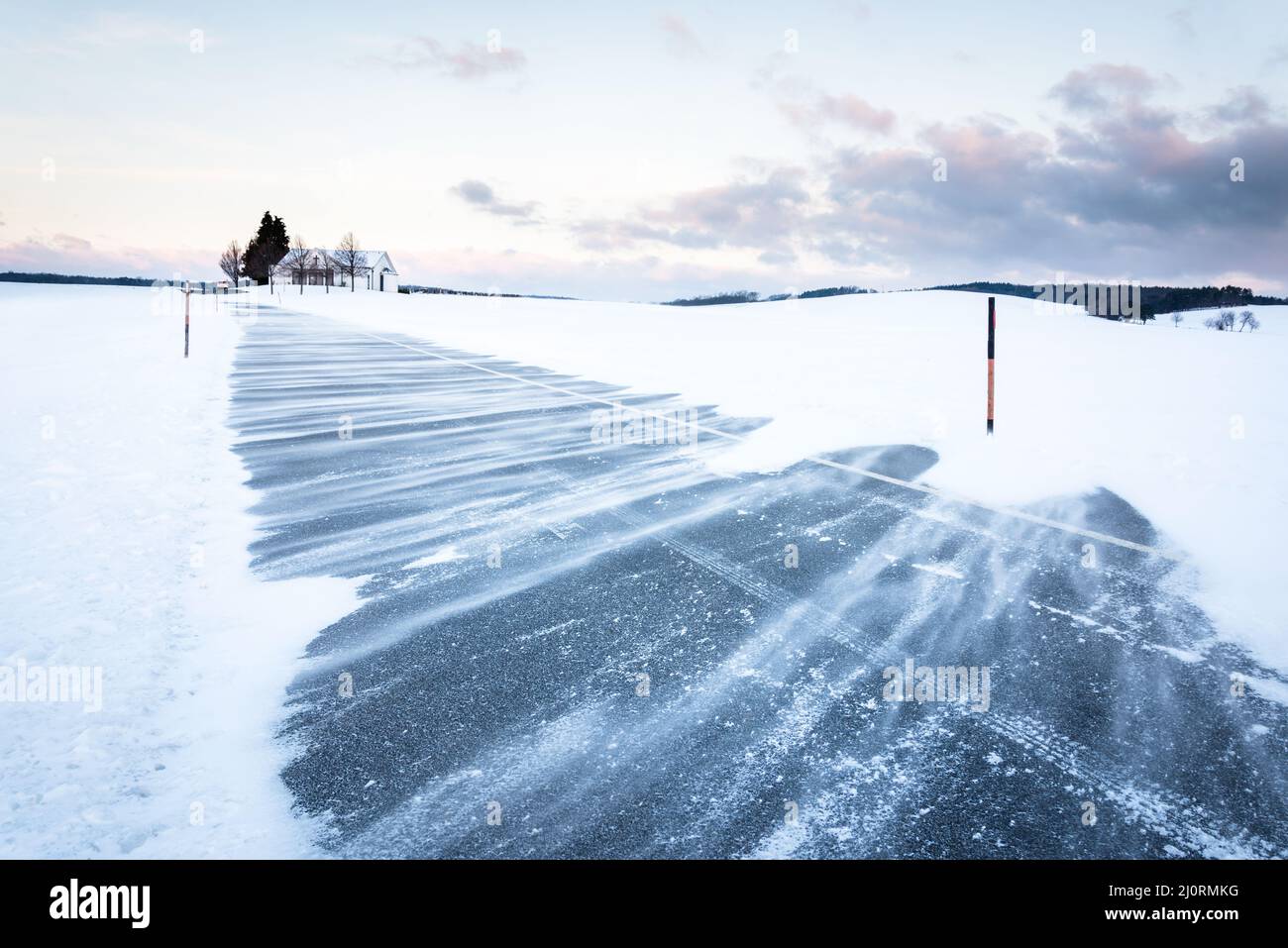 Paysage d'hiver avec village à Burgenland et dérive des neiges dans la rue Banque D'Images