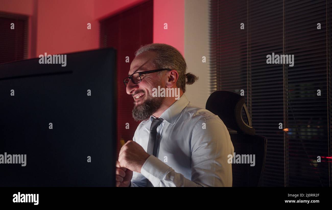 Joyeux ouvrier de bureau d'âge moyen en costume, il rit au bureau Banque D'Images