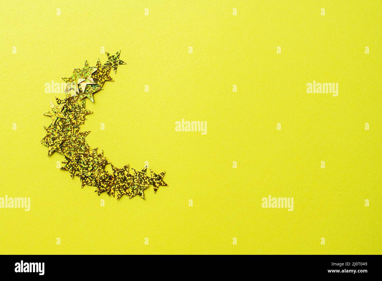 La forme de la lune du croissant de lueur brille sur un fond jaune. Vue de dessus et espace de copie. Banque D'Images