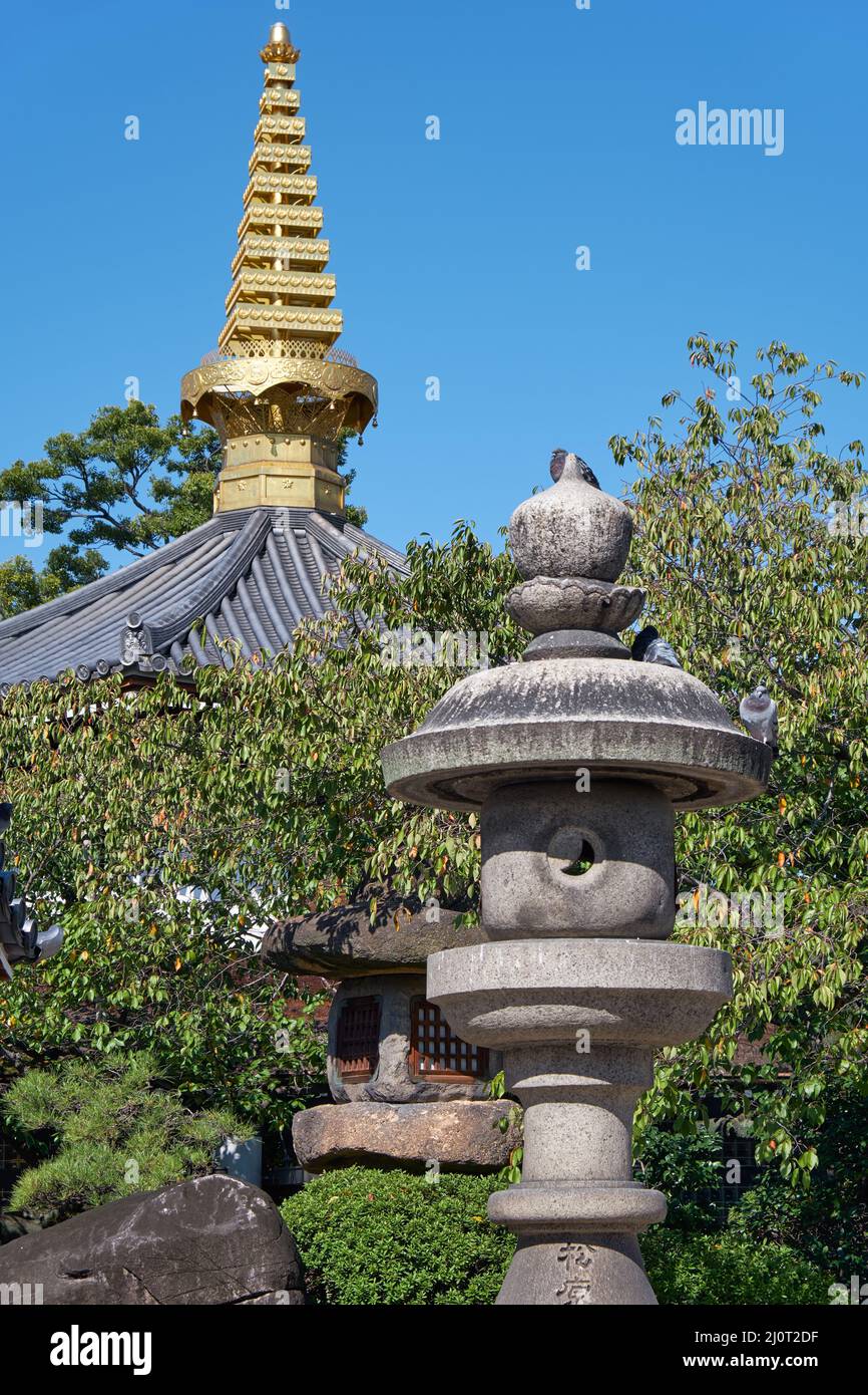 Lanternes traditionnelles en pierre avec pagode sorin sur le fond dans le jardin du temple. Osaka. Japon Banque D'Images